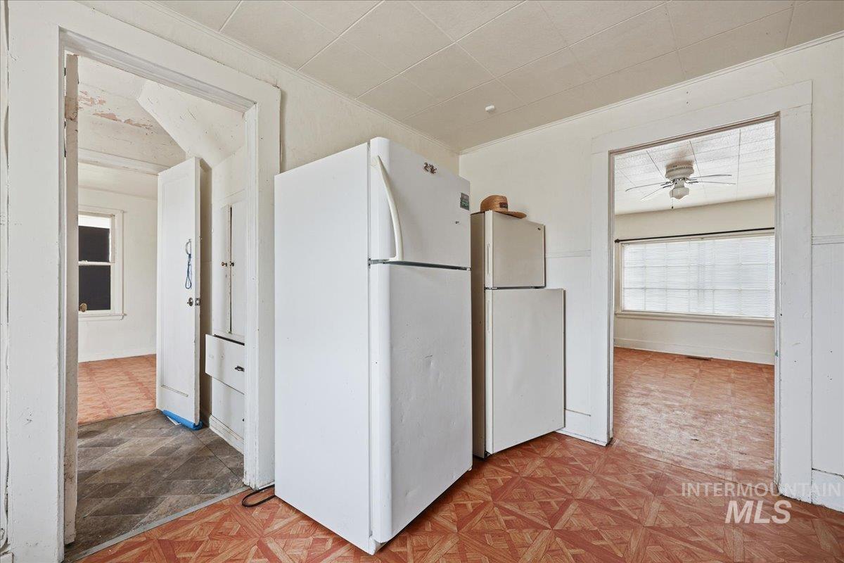 Kitchen featuring freestanding refrigerator, light flooring, and ceiling fan