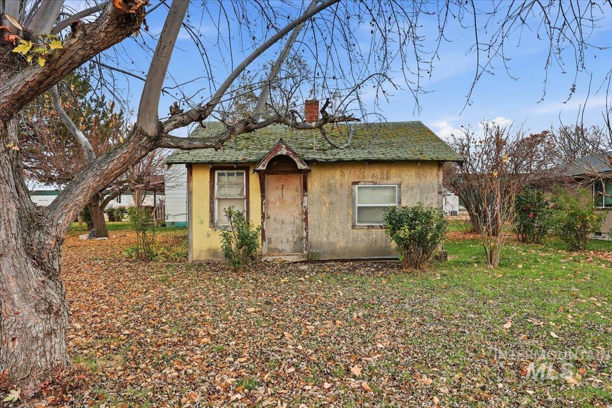 Bungalow featuring a chimney, stucco siding, and roof with shingles