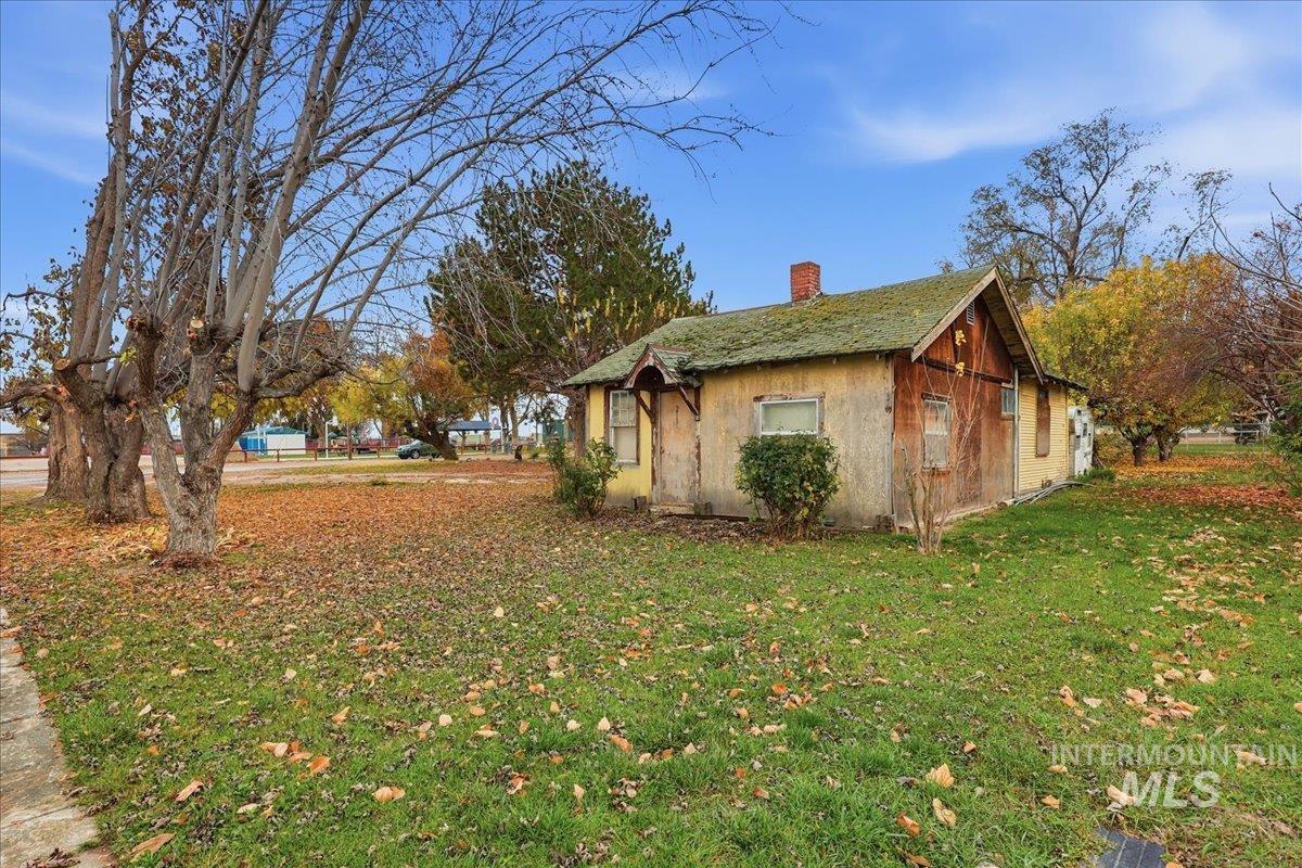 View of side of home featuring a yard and a chimney