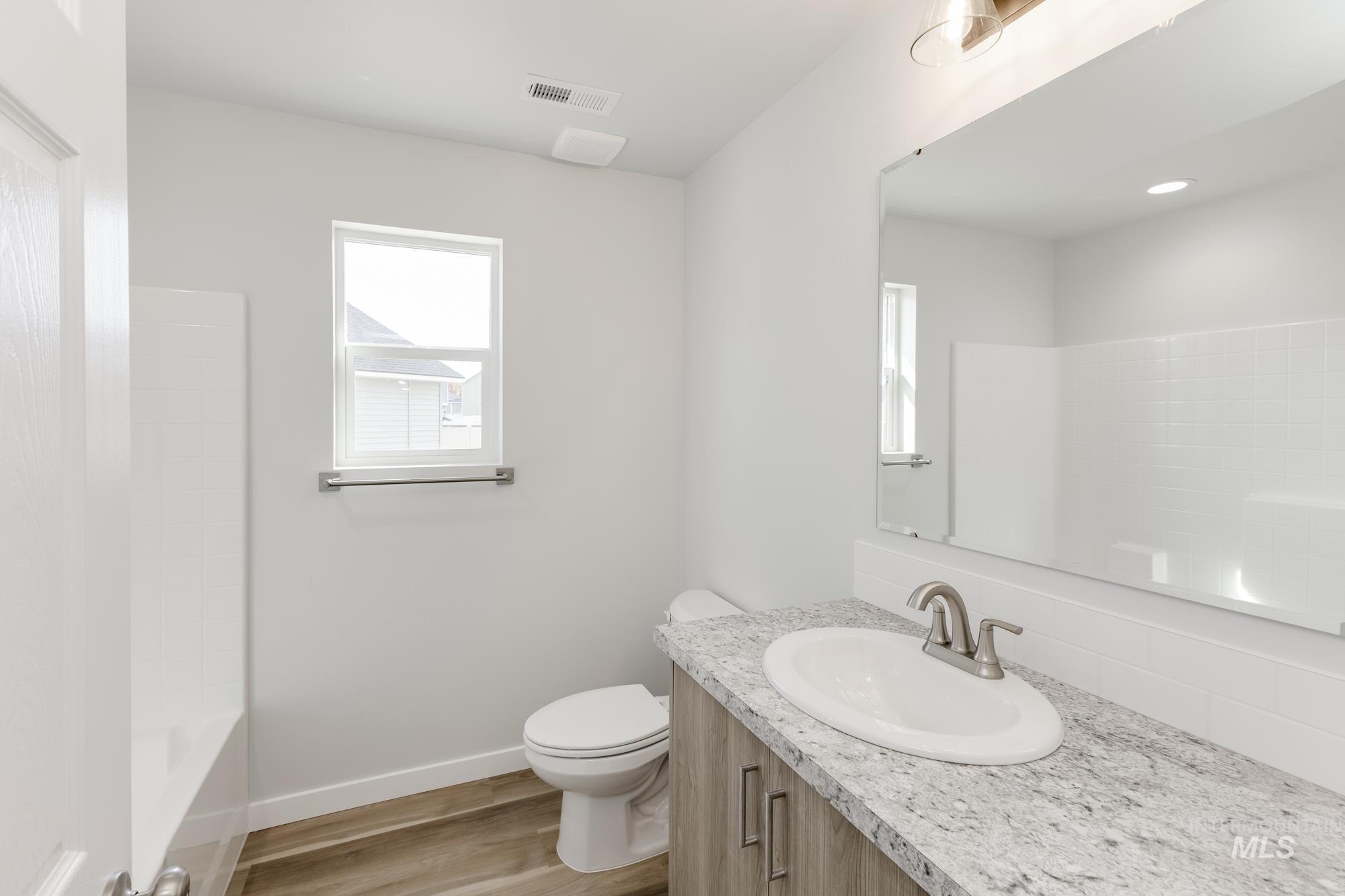 Full bathroom featuring vanity, light wood-type flooring, and shower / tub combination