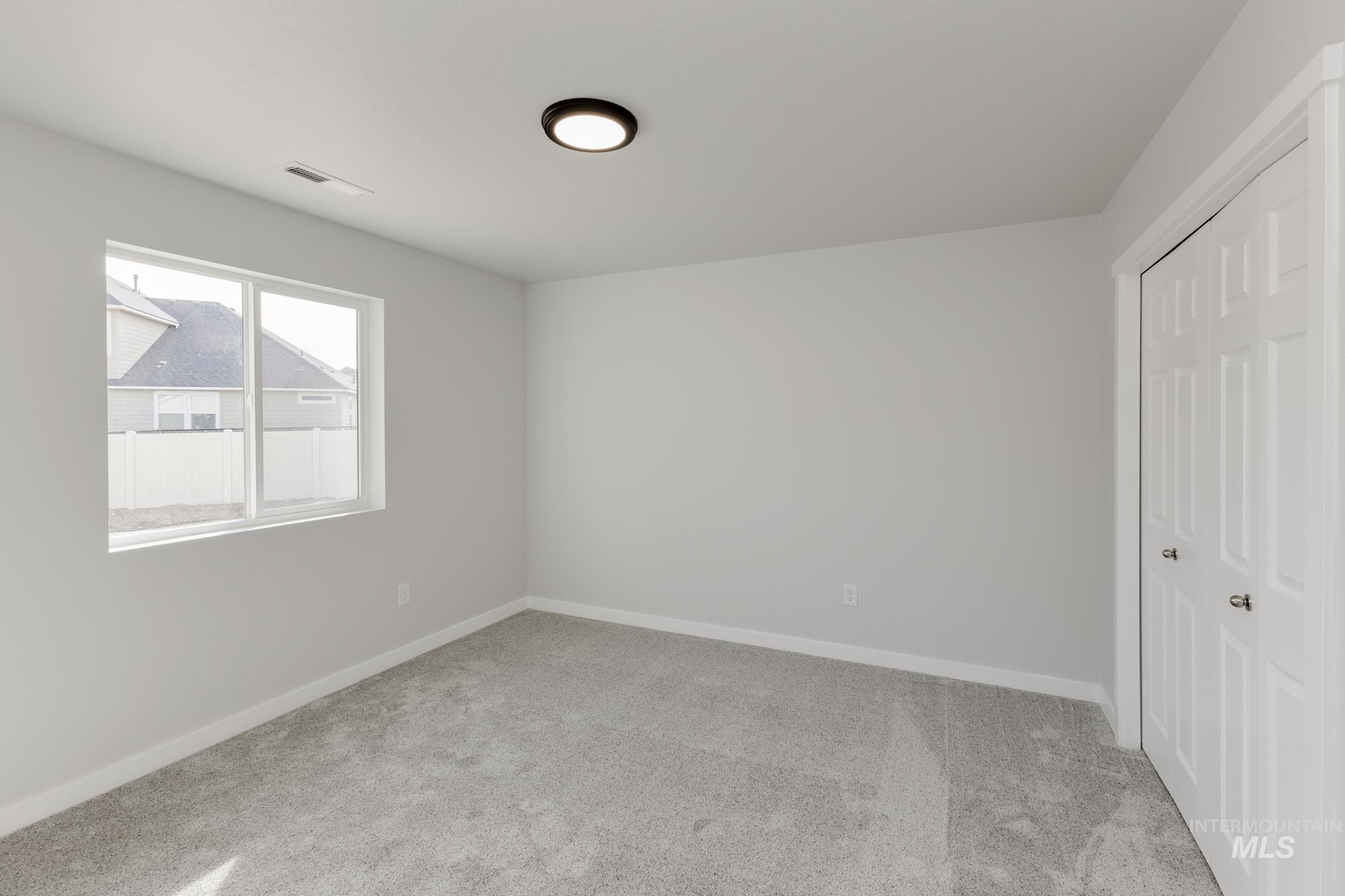 Unfurnished bedroom featuring light colored carpet and a closet