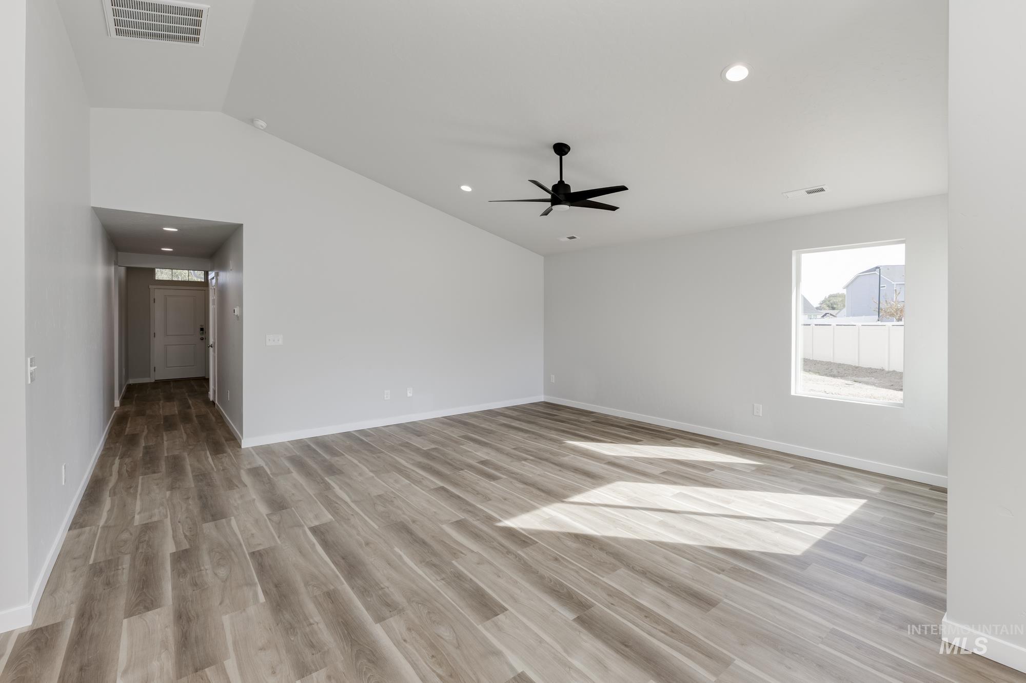 Empty room featuring vaulted ceiling, light wood-style floors, recessed lighting, and ceiling fan