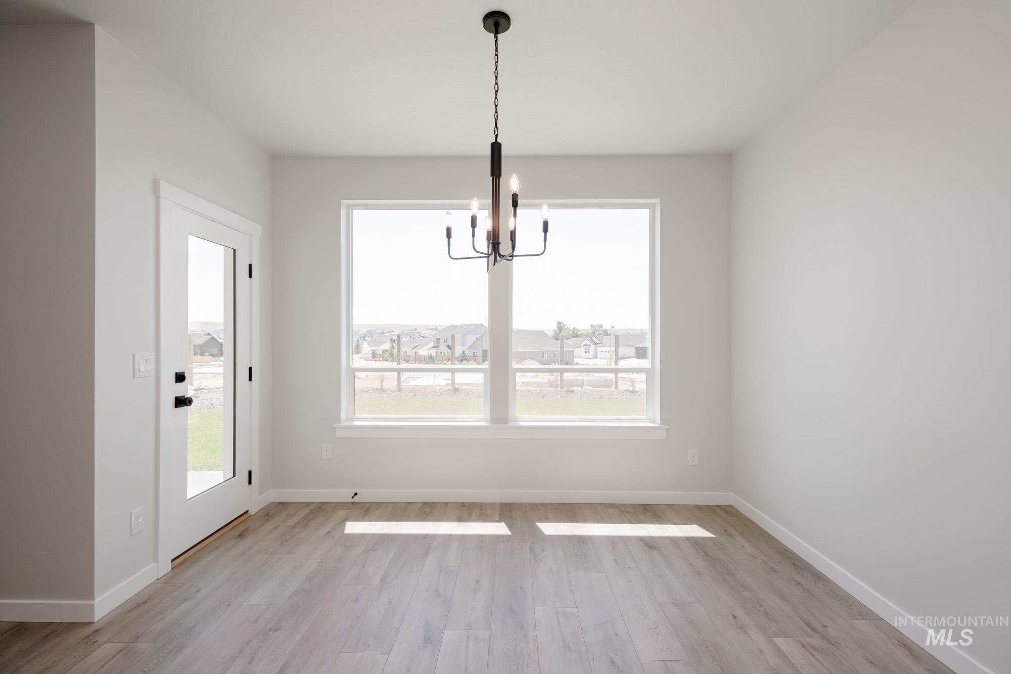 Unfurnished dining area with light wood-type flooring and a chandelier