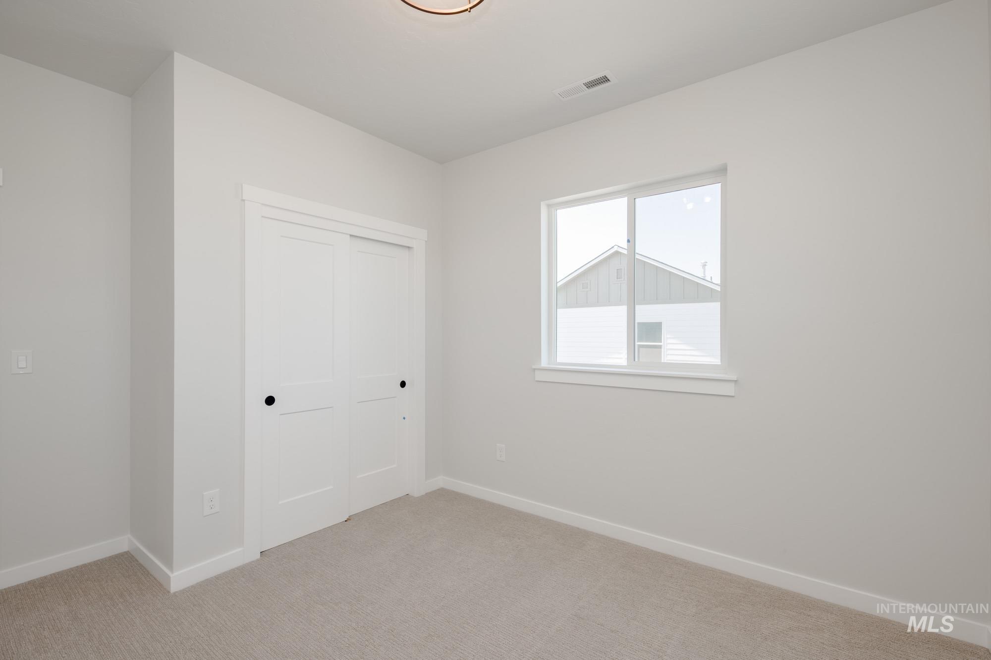 Unfurnished bedroom featuring light colored carpet and a closet
