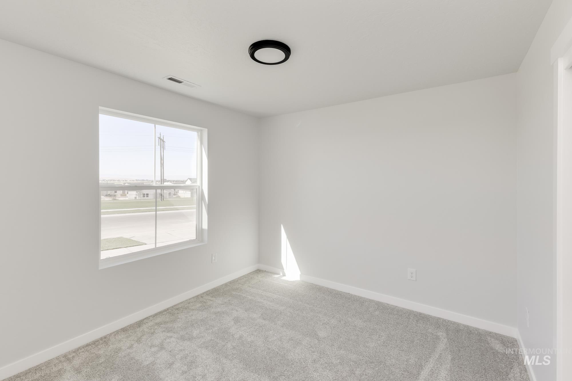 Carpeted empty room featuring baseboards