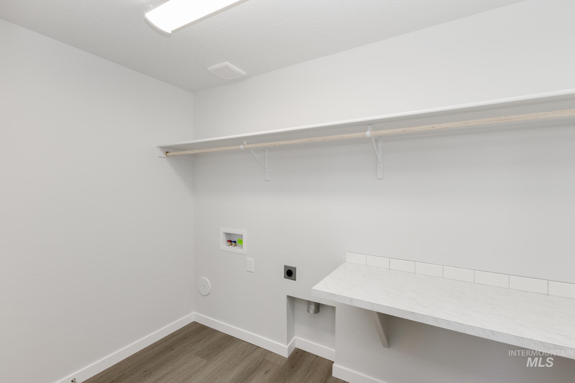 Laundry room with dark wood-style floors, hookup for an electric dryer, and washer hookup