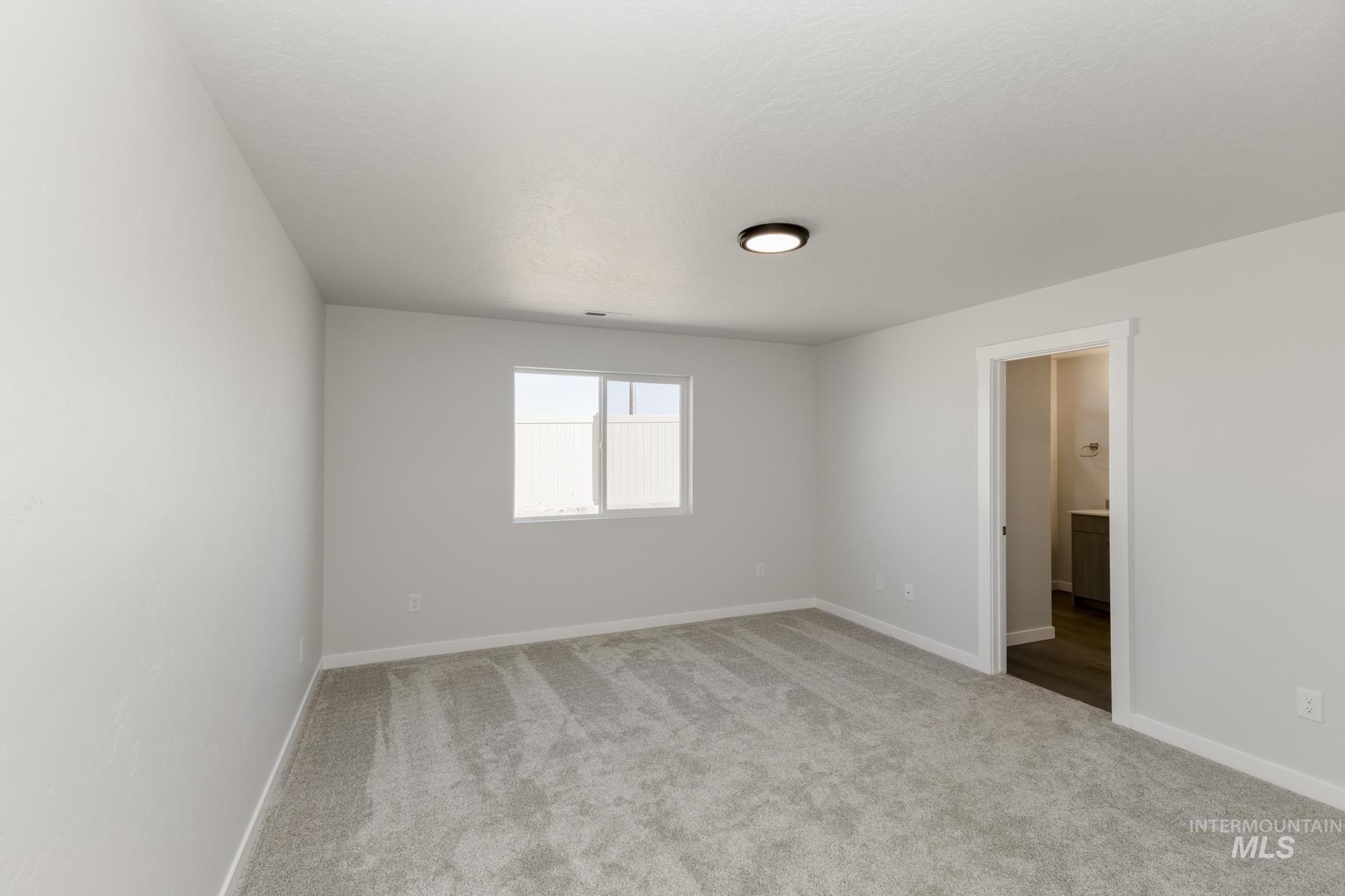 Unfurnished room with light carpet and baseboards
