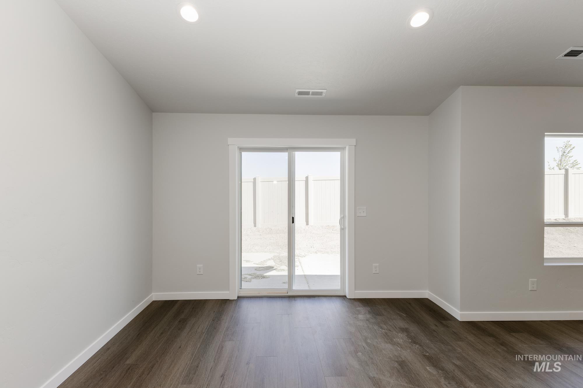 Spare room featuring dark wood-style floors, healthy amount of natural light, and recessed lighting