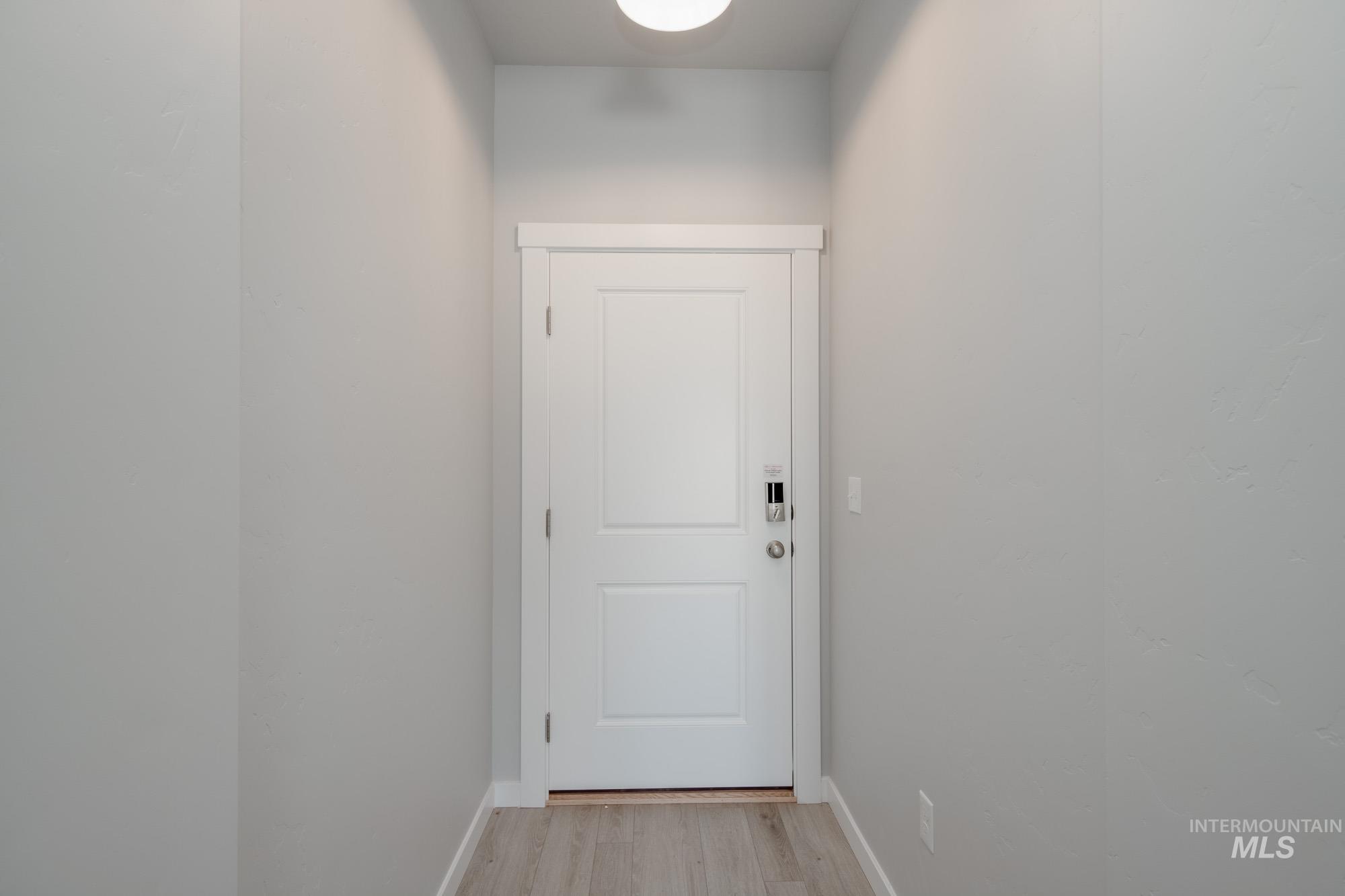 Doorway featuring baseboards and wood finished floors