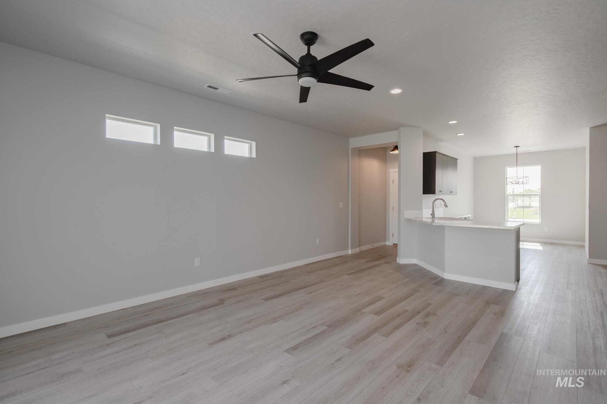 Unfurnished living room with light wood-type flooring, recessed lighting, and a ceiling fan
