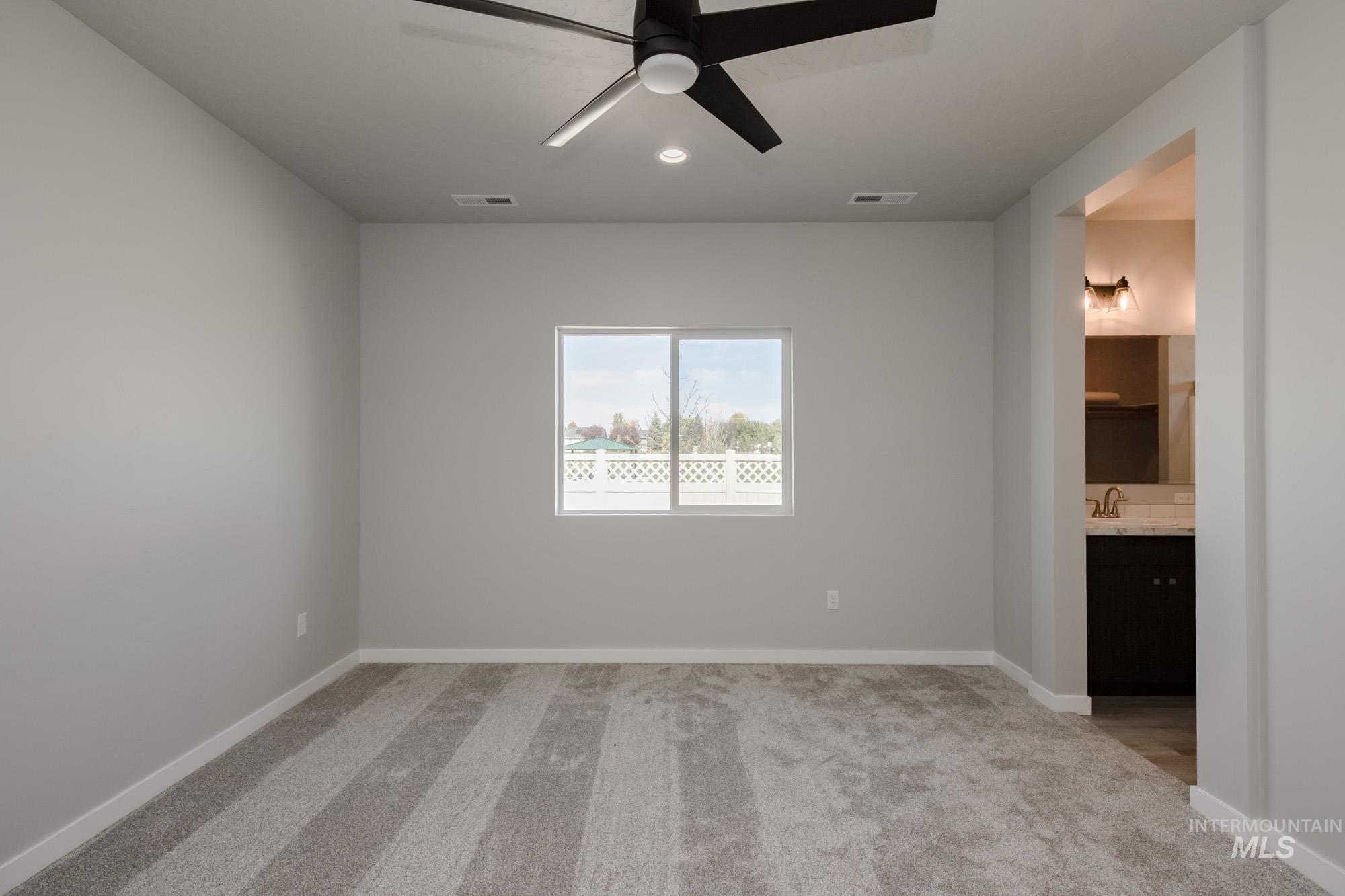 Empty room featuring light carpet, ceiling fan, and recessed lighting