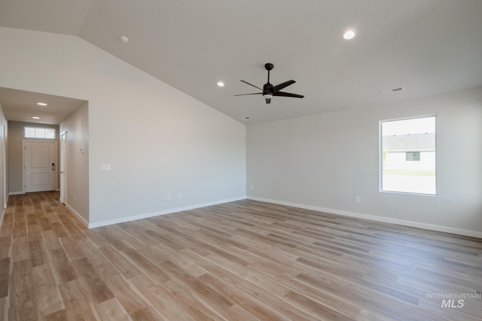 Unfurnished room with recessed lighting, light wood-style flooring, and vaulted ceiling