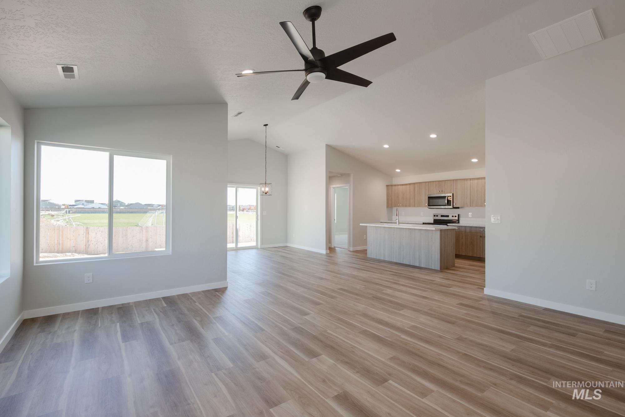 Unfurnished living room featuring light wood-type flooring, lofted ceiling, recessed lighting, and ceiling fan
