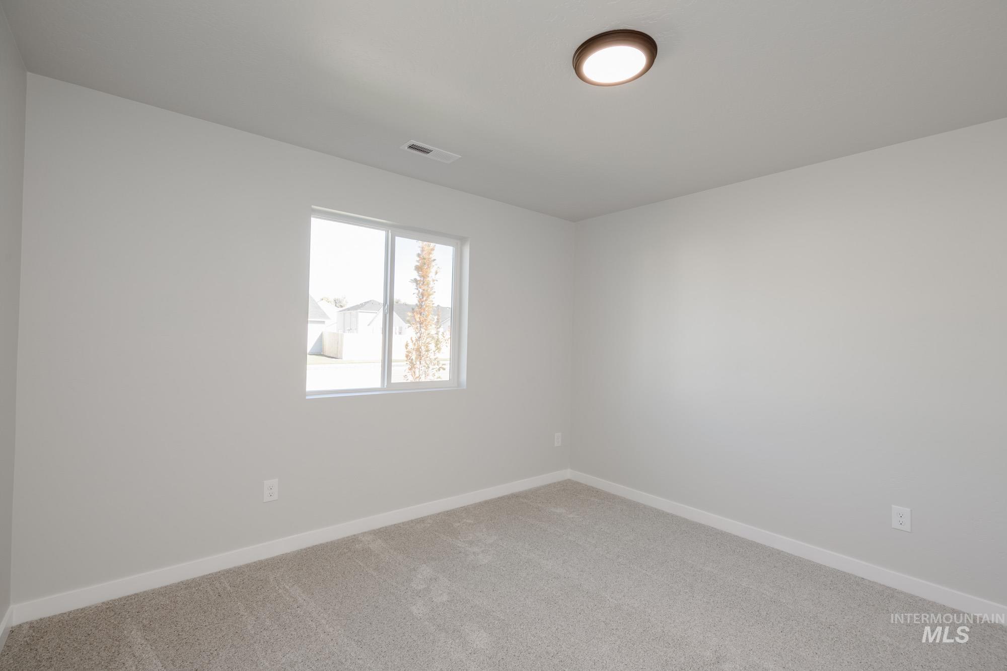 Spare room featuring carpet and baseboards