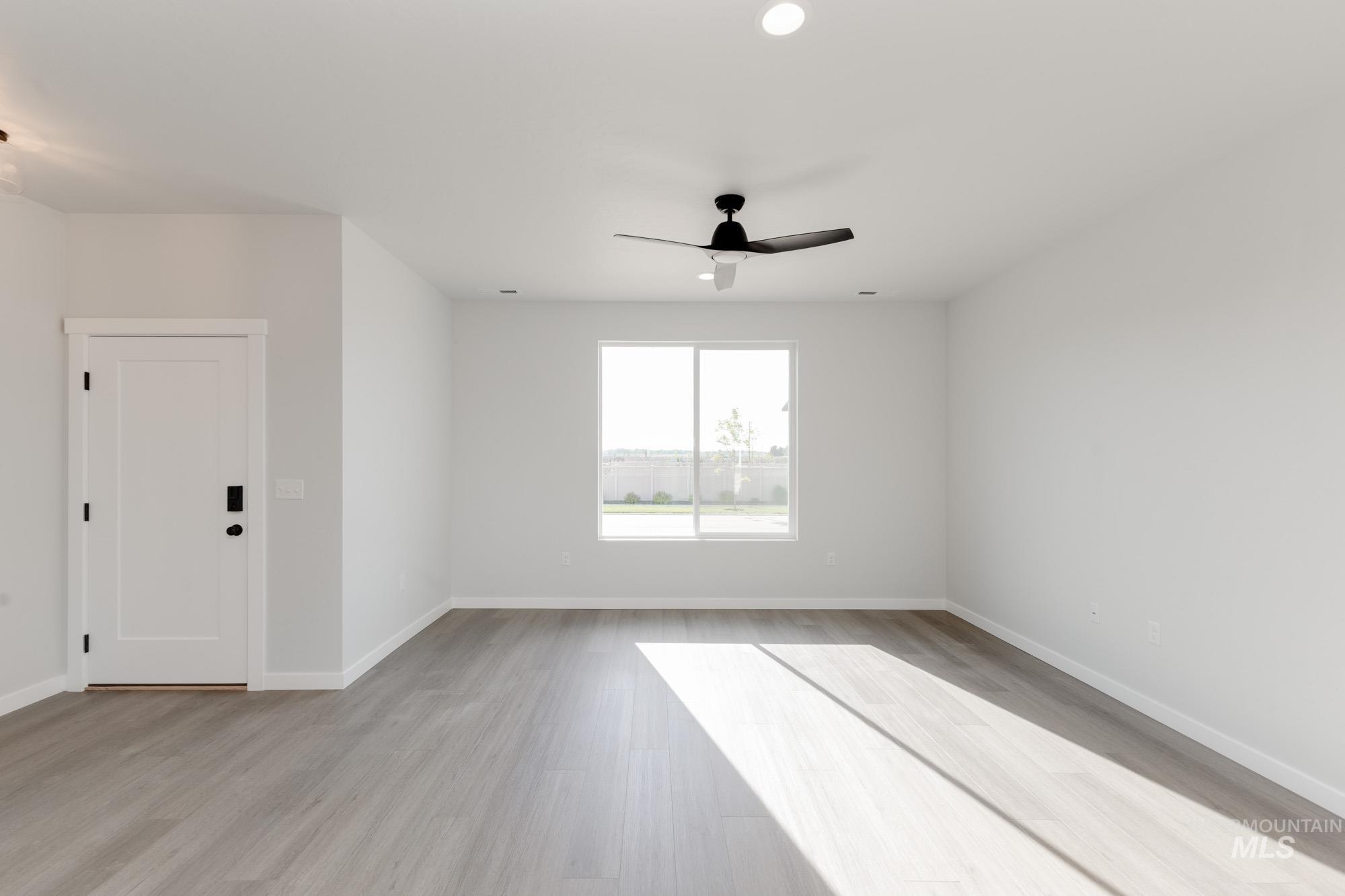 Empty room featuring light wood-style floors, a ceiling fan, and recessed lighting