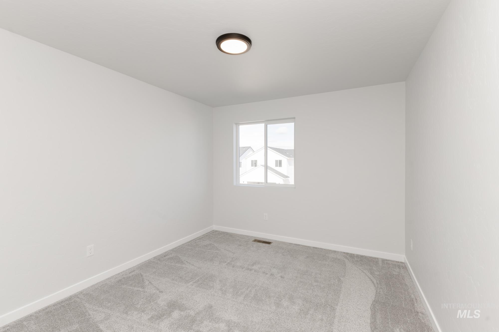 Spare room featuring carpet flooring and baseboards