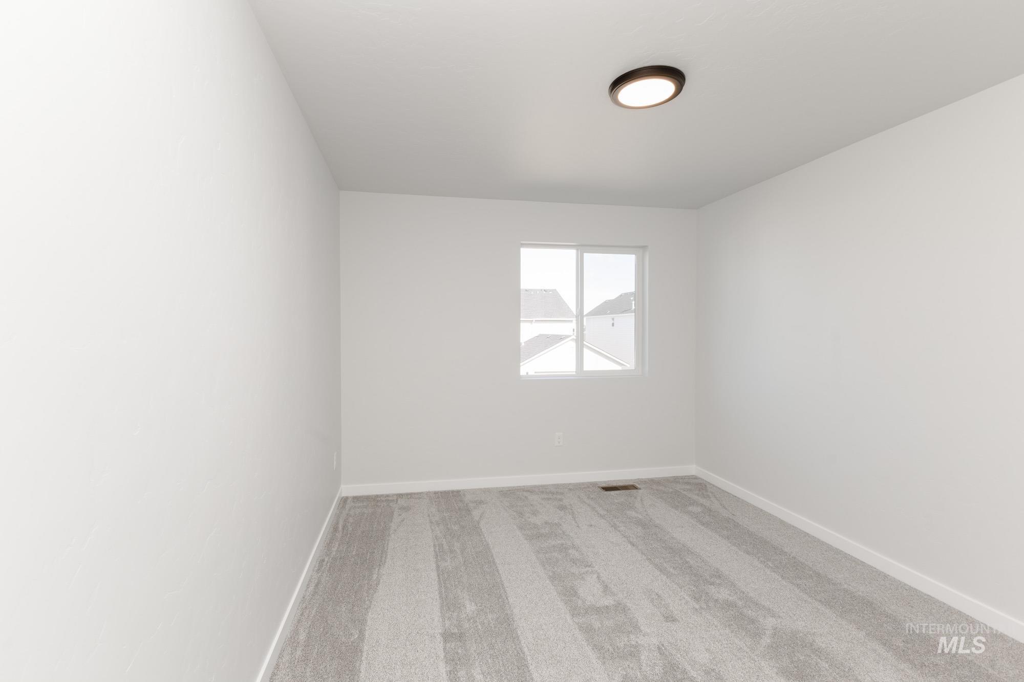 Unfurnished room with light colored carpet and baseboards