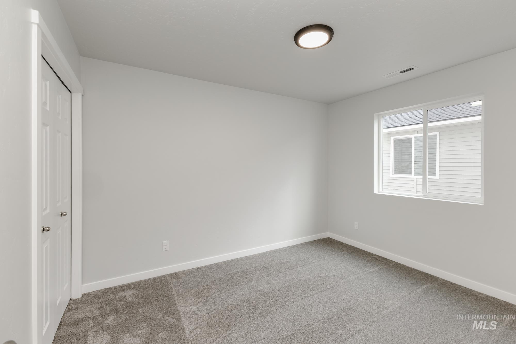 Spare room featuring light colored carpet