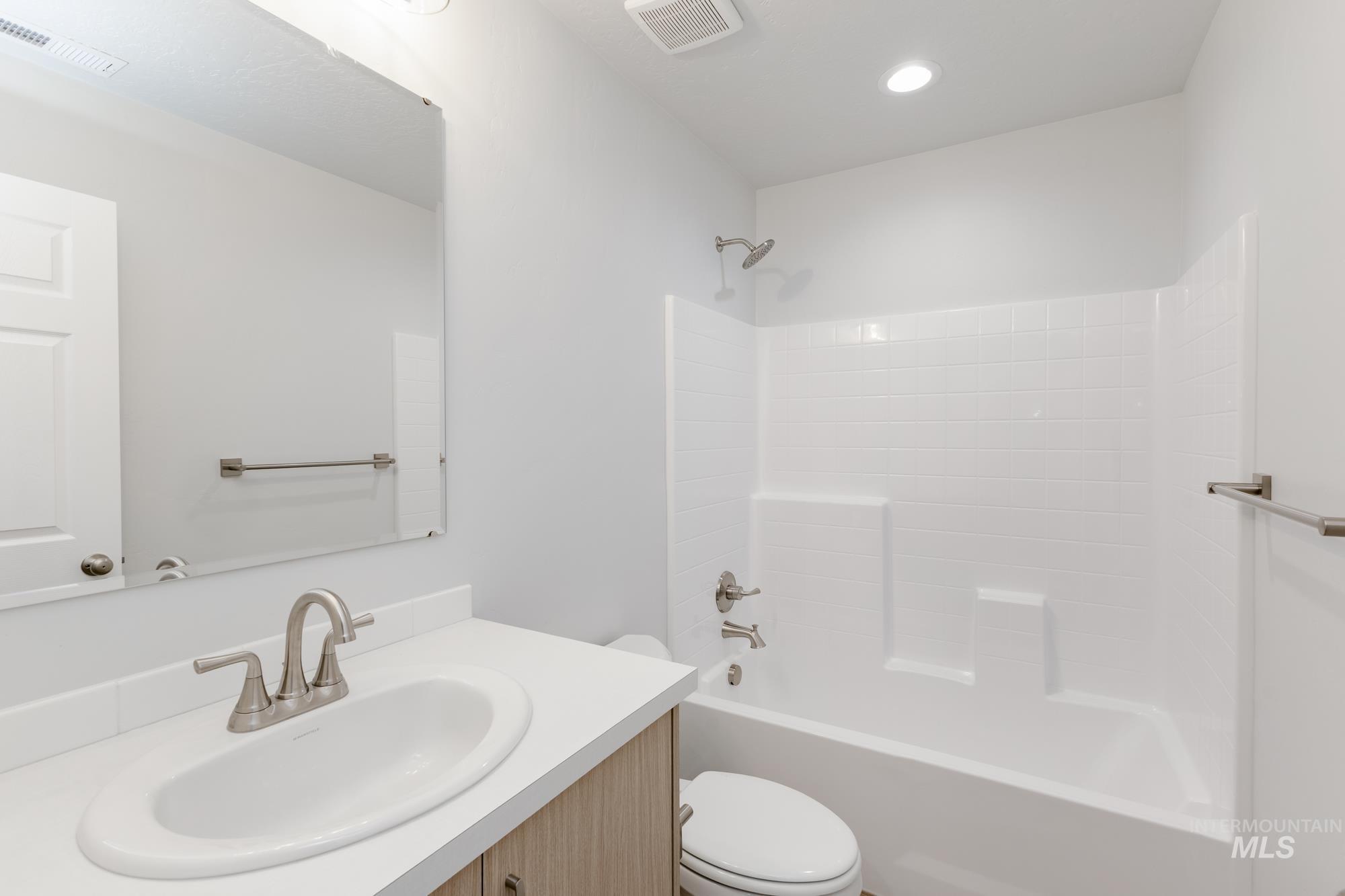 Bathroom featuring bathing tub / shower combination, vanity, and recessed lighting