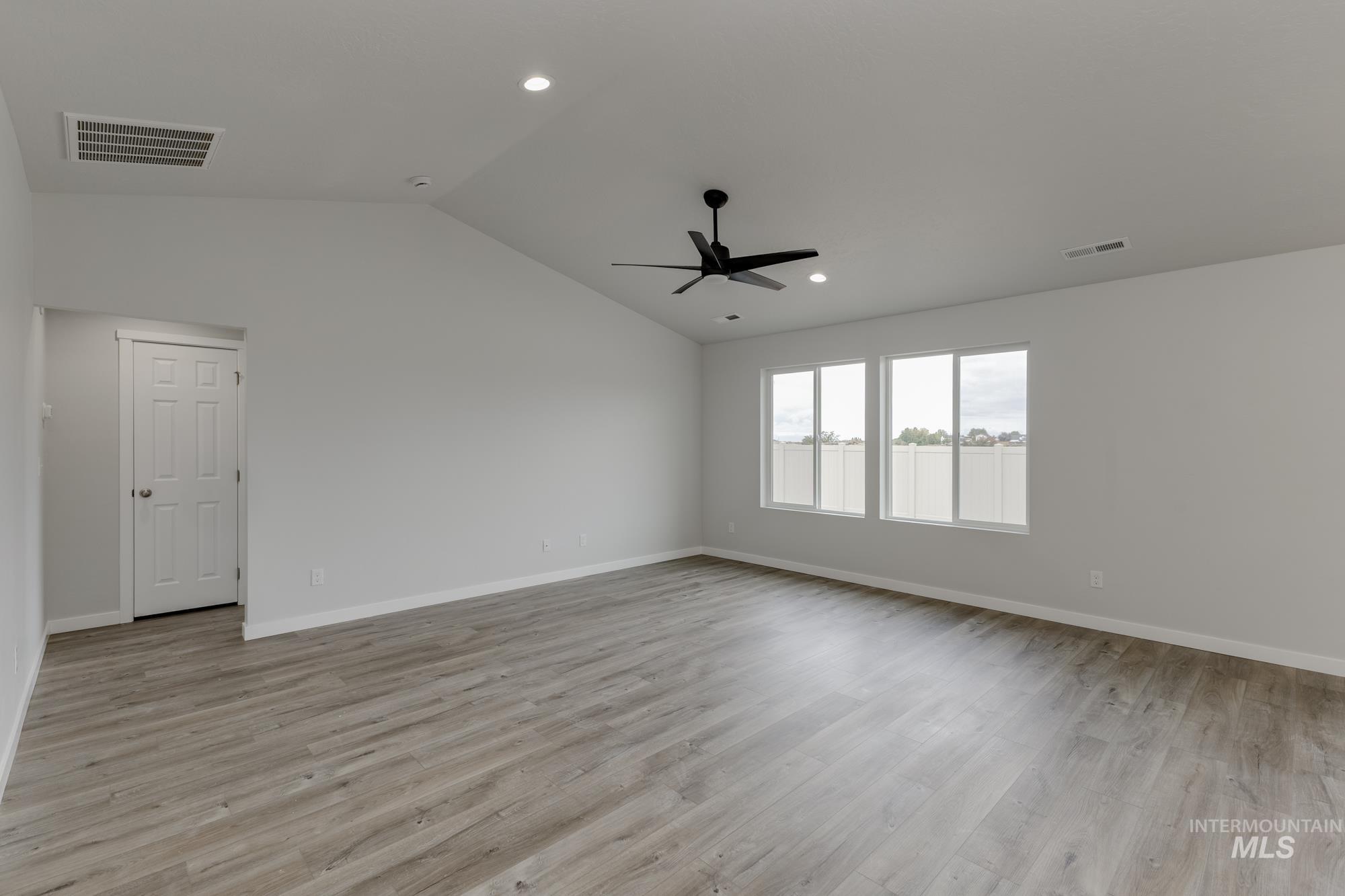 Empty room featuring light wood finished floors, vaulted ceiling, recessed lighting, and a ceiling fan
