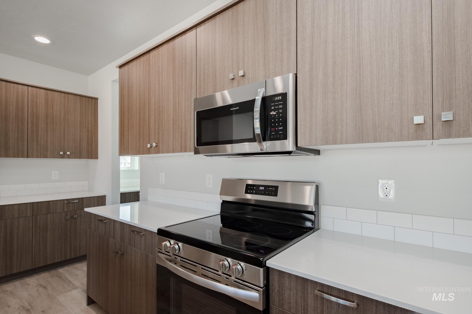 Kitchen featuring stainless steel appliances, modern cabinets, and light wood-style floors