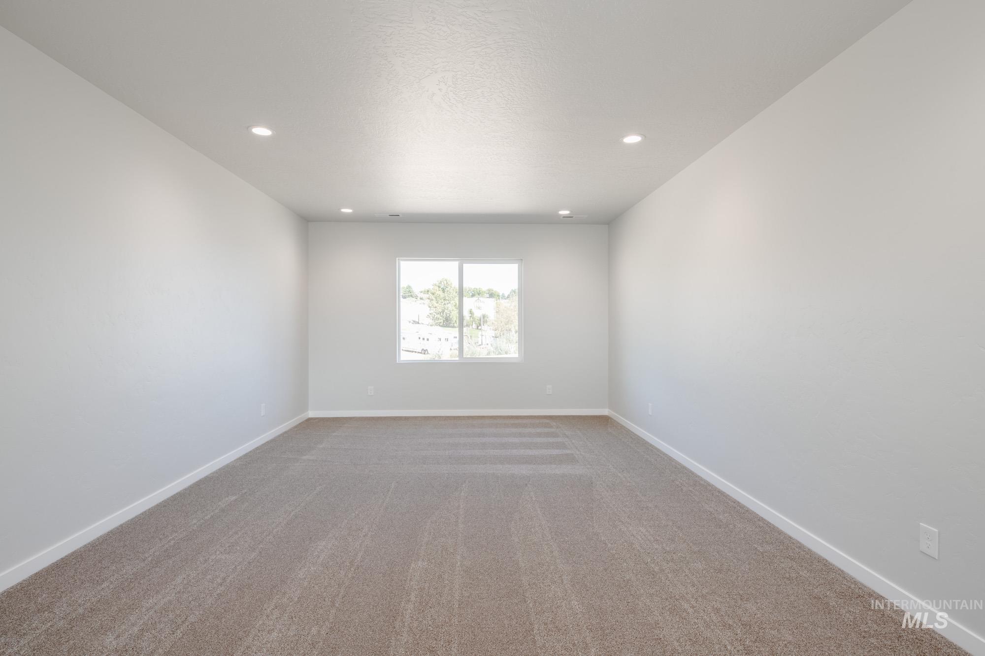 Spare room featuring light colored carpet, recessed lighting, and a textured ceiling