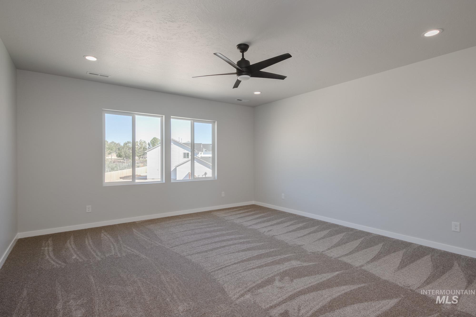 Spare room featuring carpet floors, ceiling fan, recessed lighting, and a textured ceiling