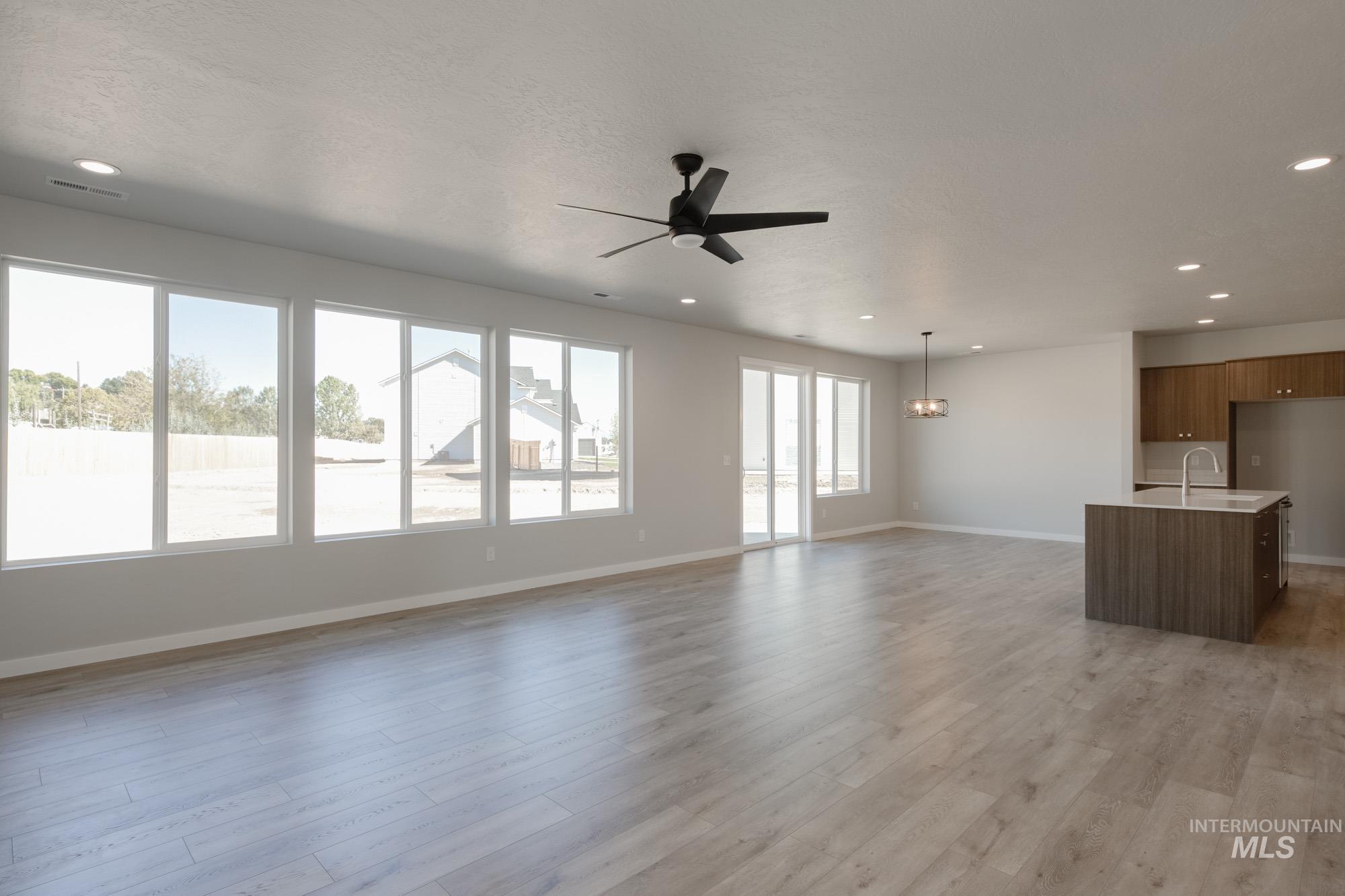 Unfurnished living room featuring light wood-type flooring, recessed lighting, and a ceiling fan