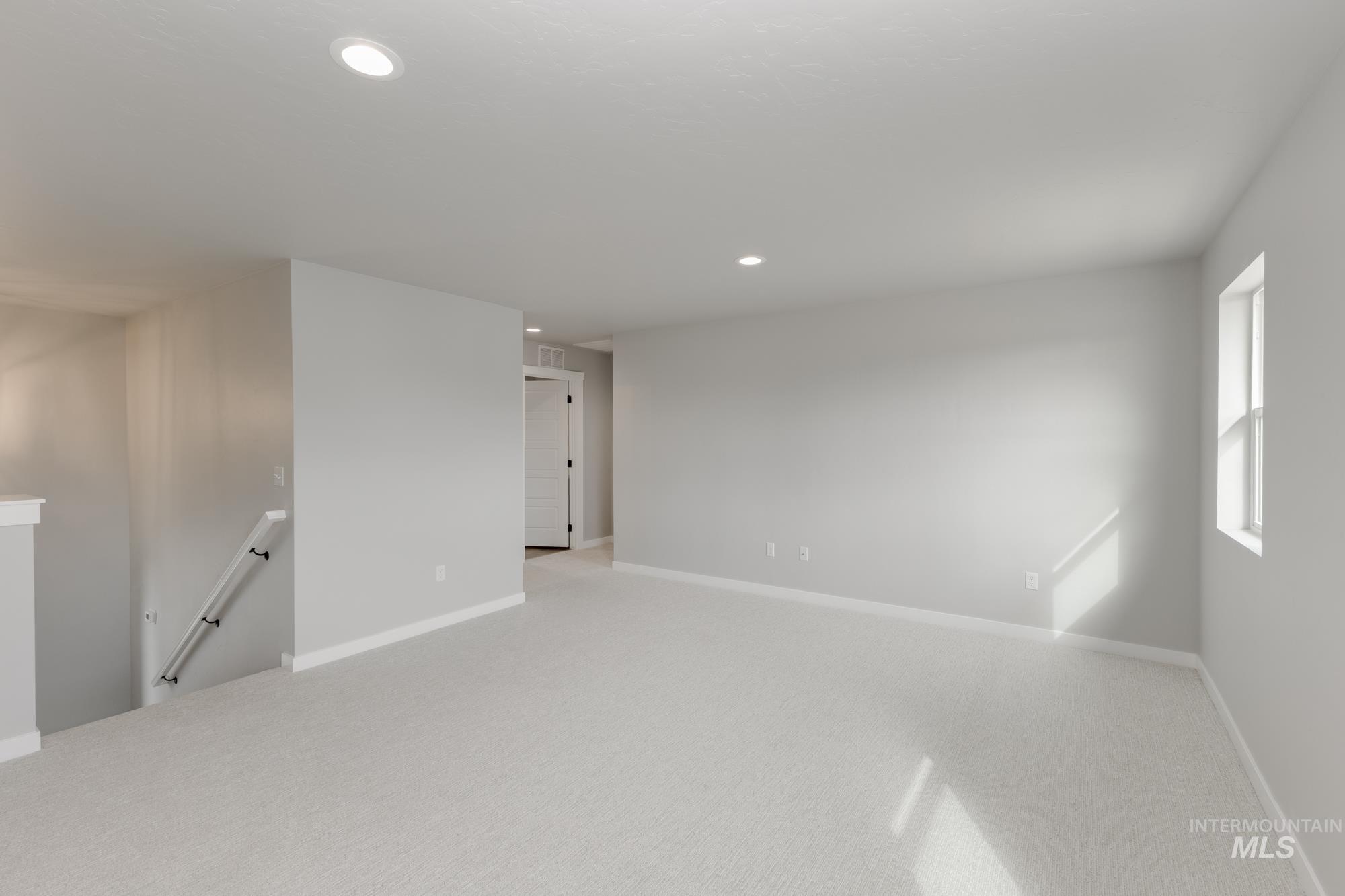 Empty room with recessed lighting and light carpet