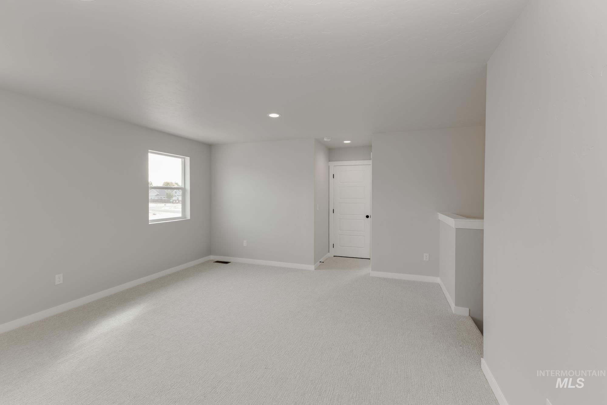 Spare room featuring light colored carpet and recessed lighting