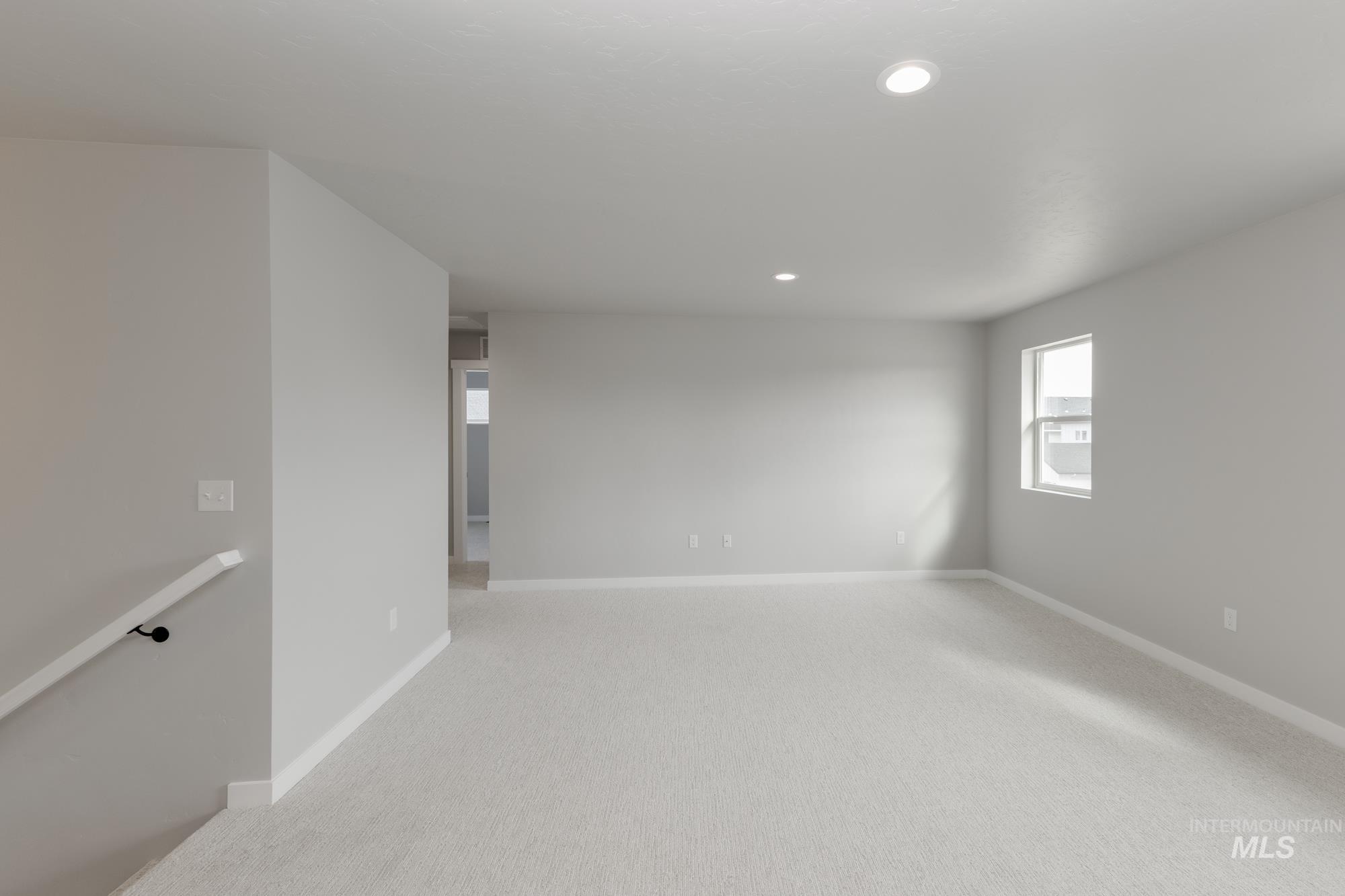 Spare room featuring light colored carpet and recessed lighting