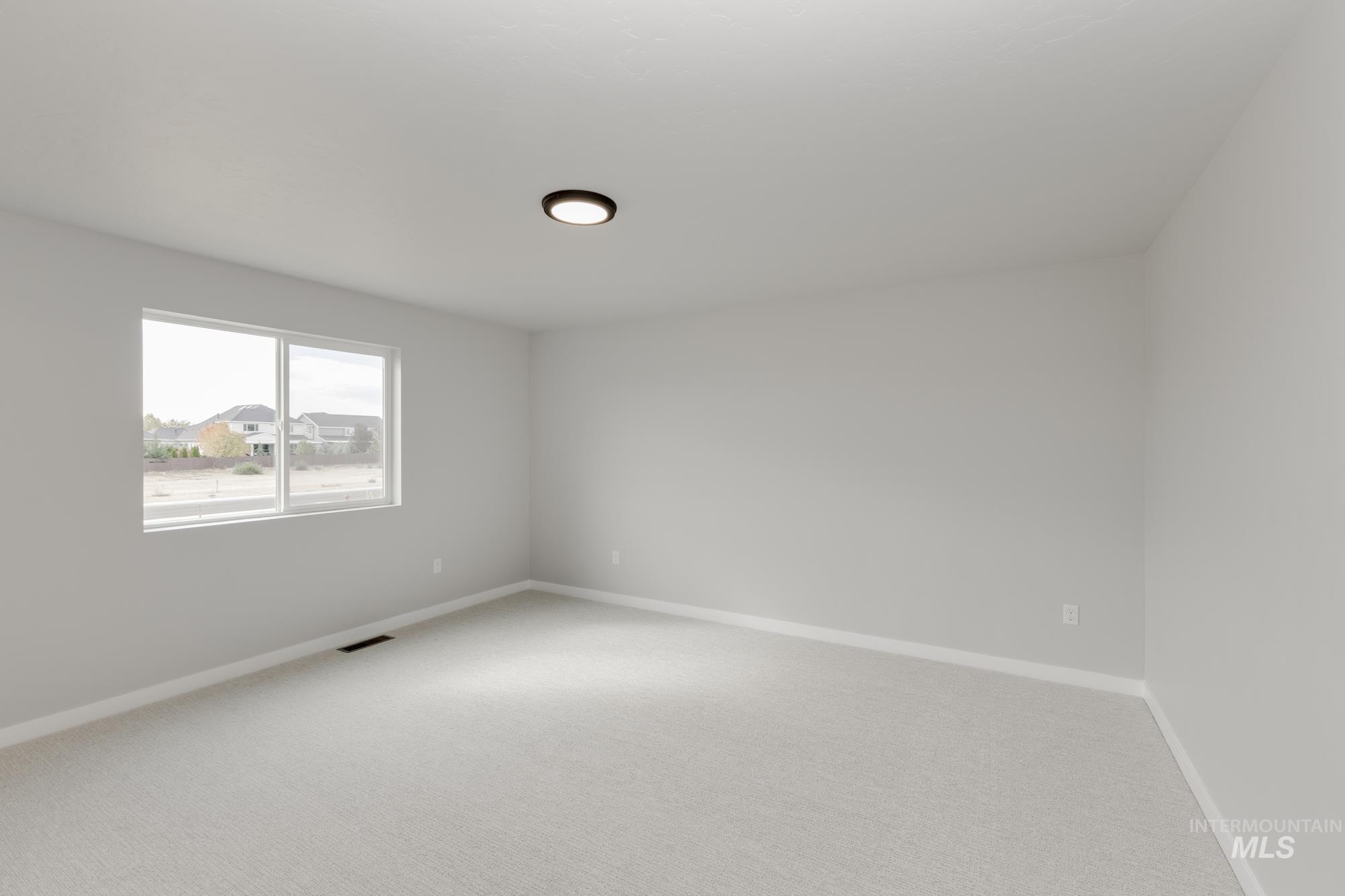 Carpeted empty room with baseboards