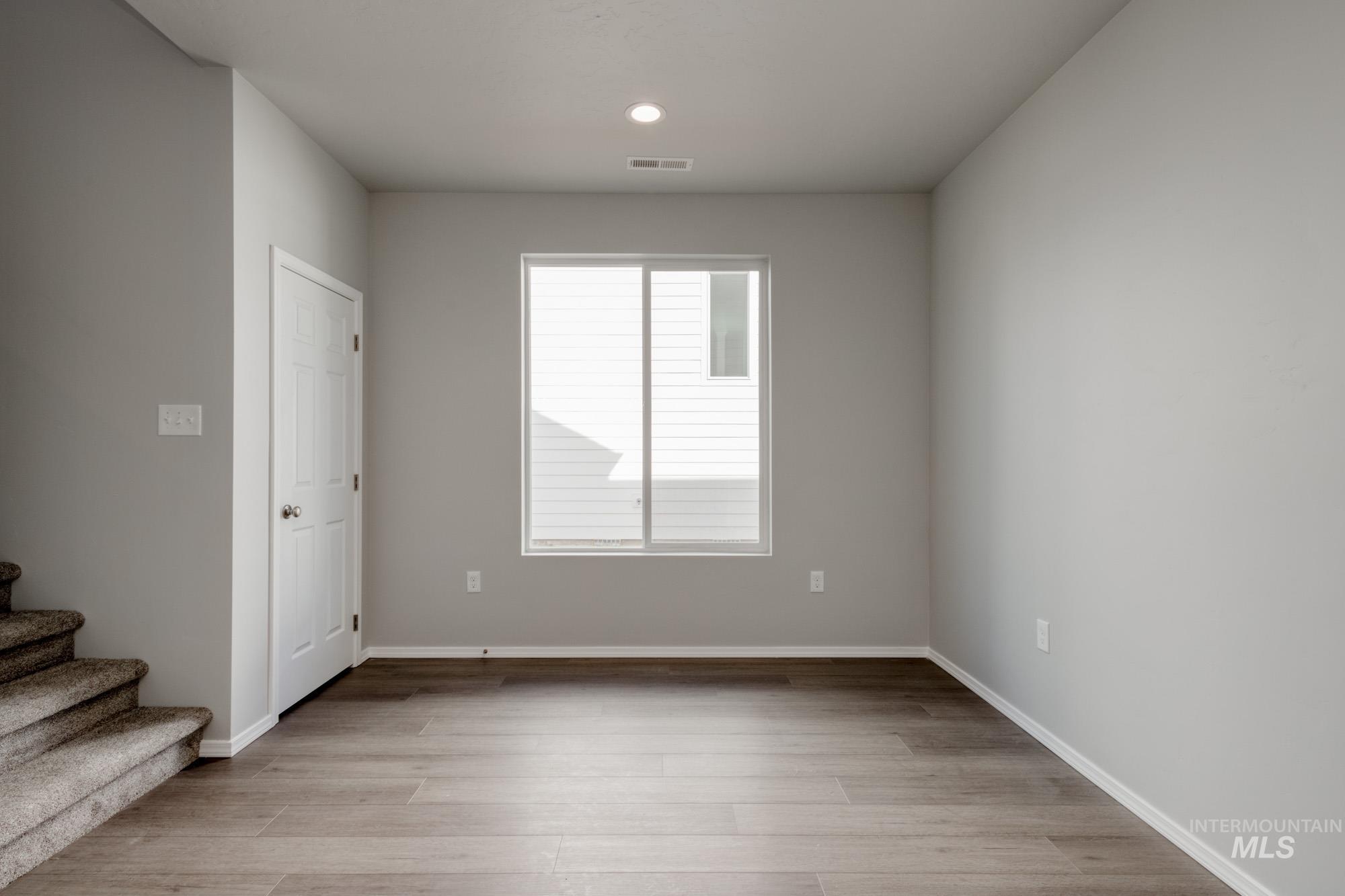 Spare room with light wood finished floors, stairs, and recessed lighting