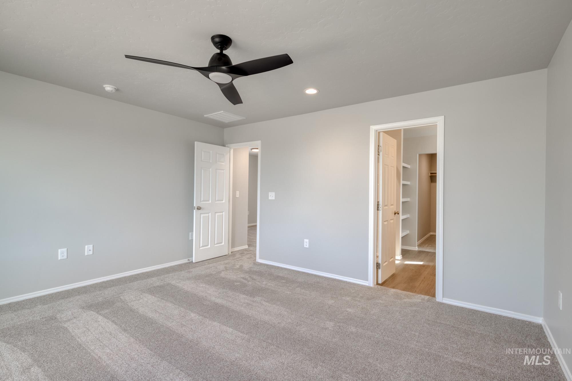 Unfurnished bedroom featuring light carpet, ceiling fan, and recessed lighting