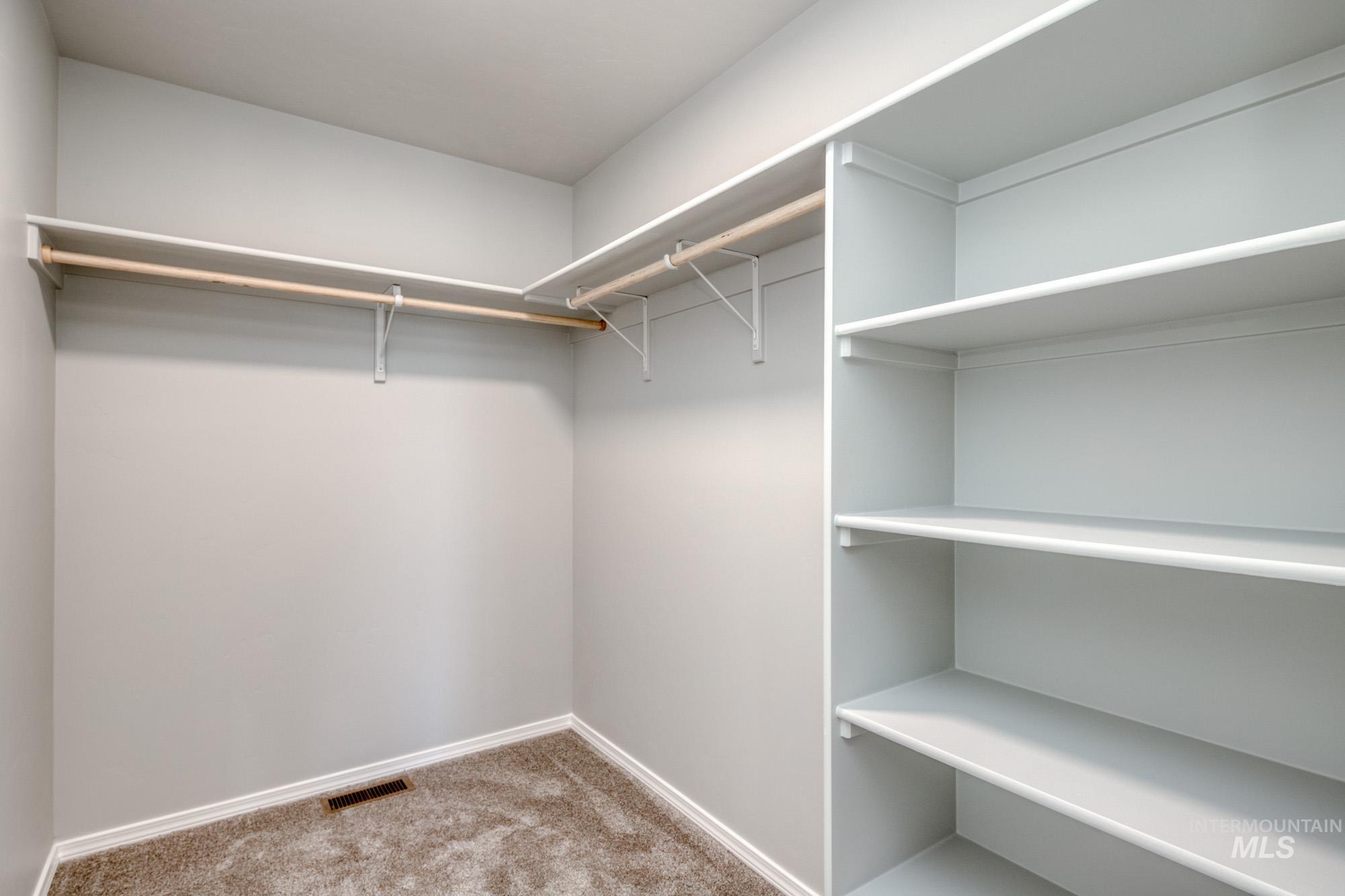 Spacious closet with light colored carpet