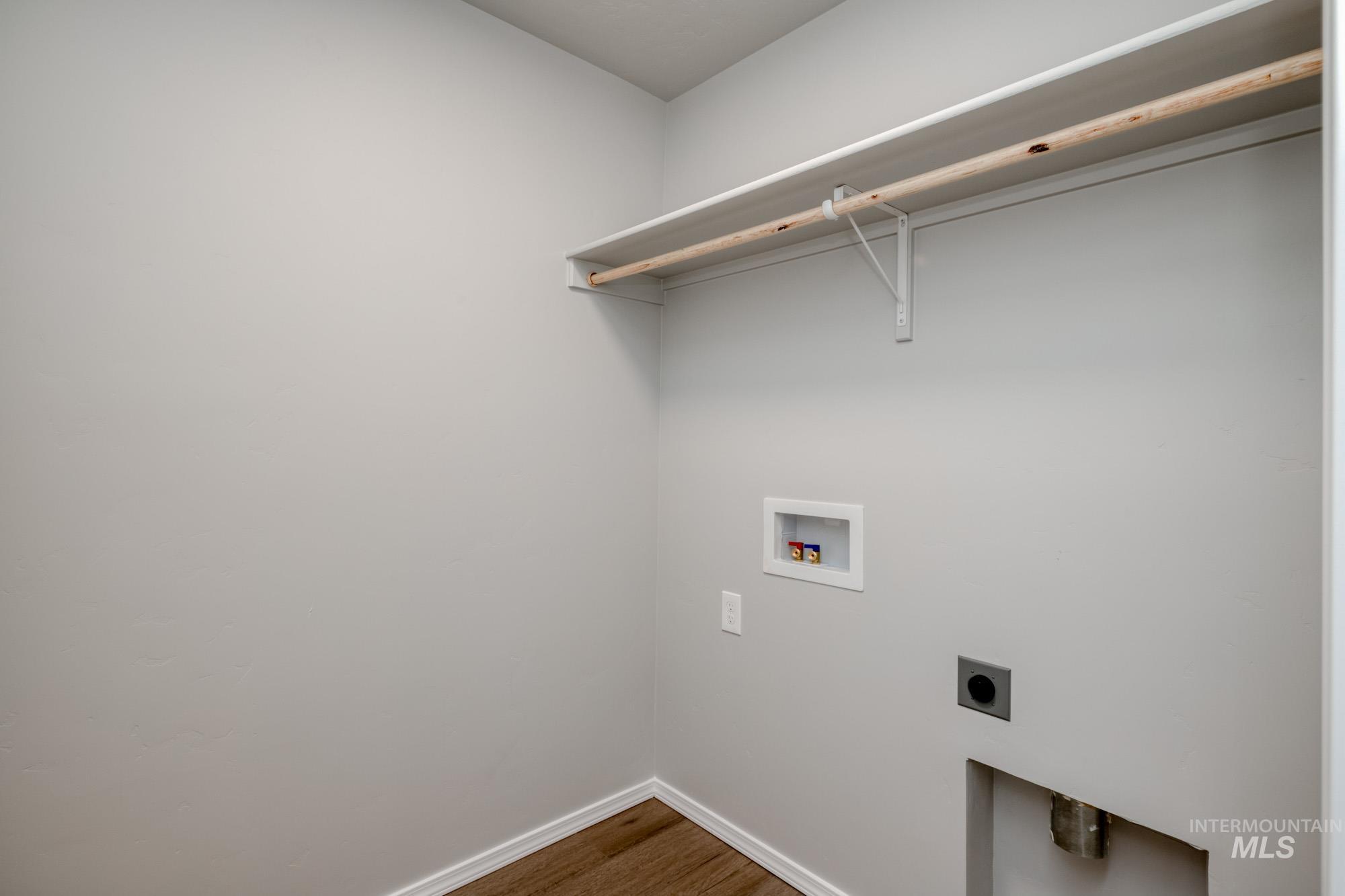 Washroom with wood finished floors, hookup for a washing machine, and electric dryer hookup