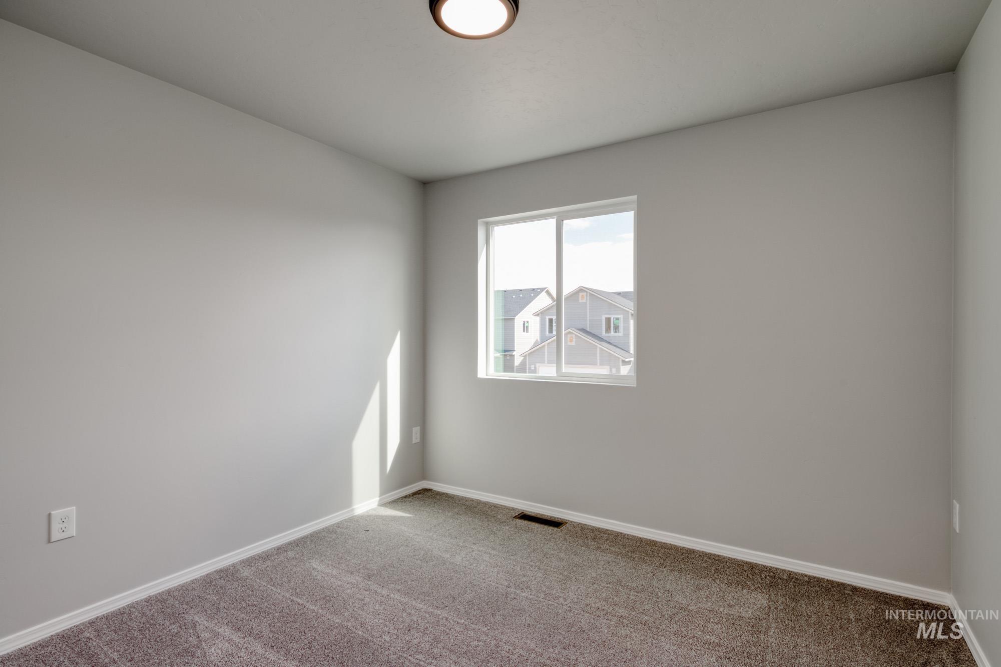 Carpeted empty room featuring baseboards