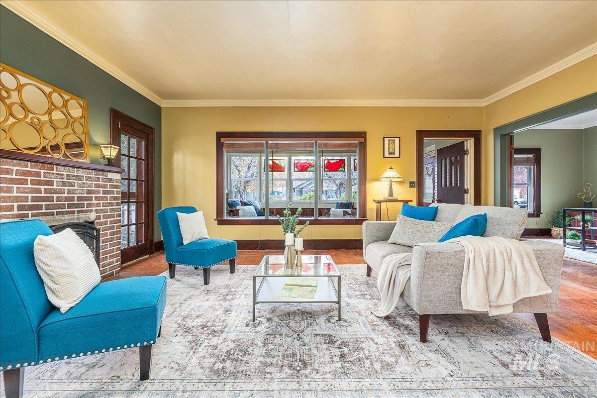 Living area featuring crown molding, wood finished floors, and a fireplace