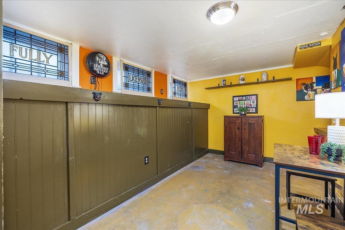 Bar area featuring unfinished concrete flooring, a textured ceiling, and healthy amount of natural light