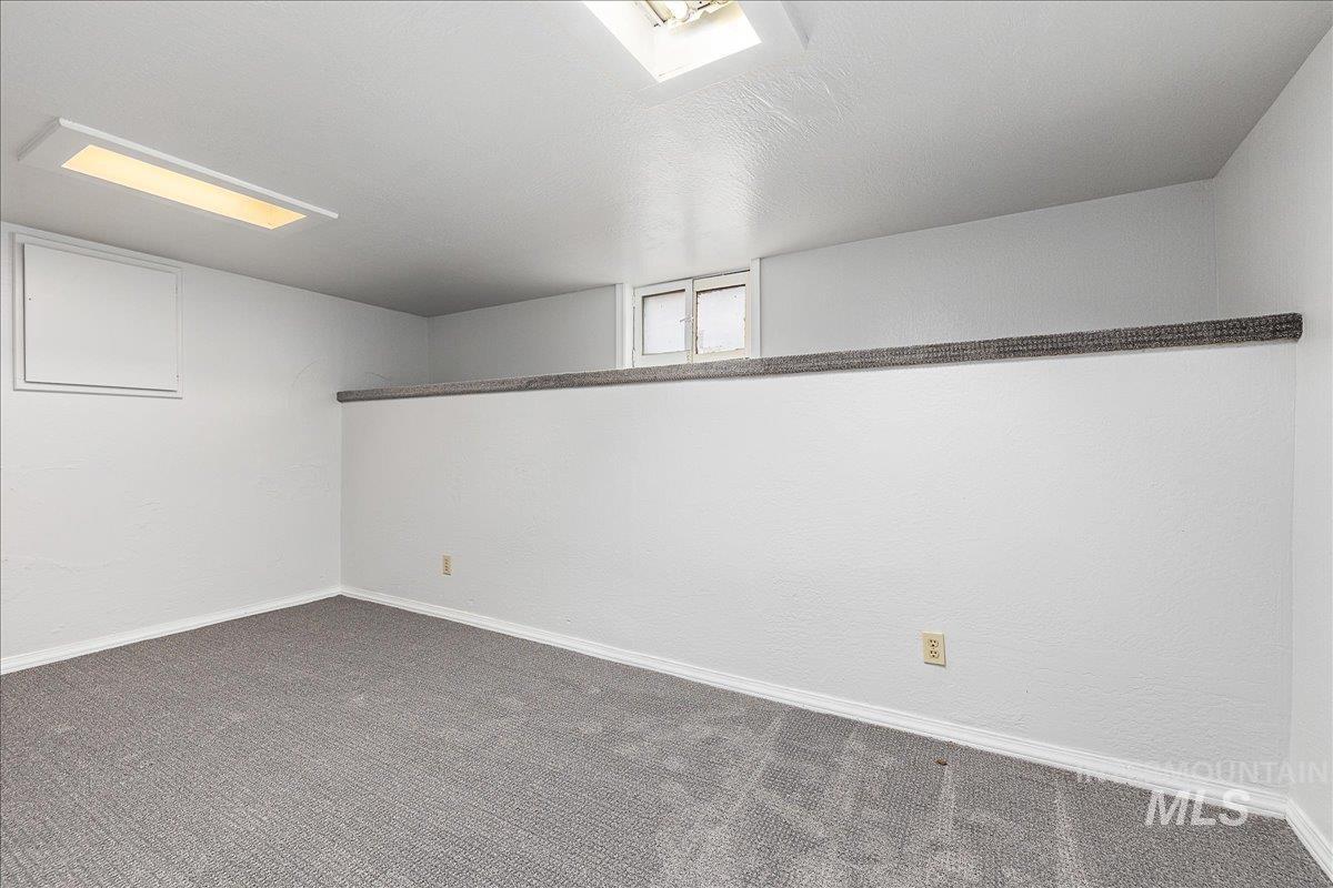 Below grade area with carpet flooring and a textured wall