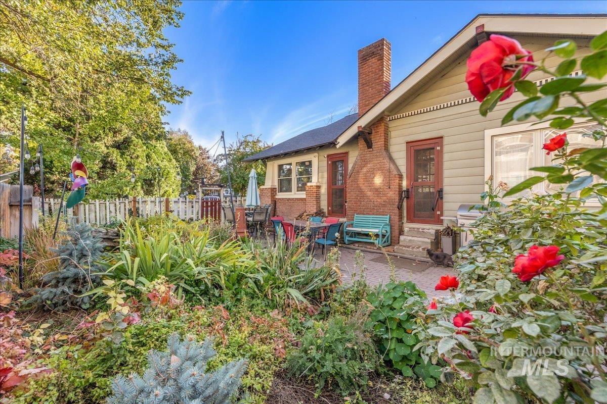 Rear view of property featuring a chimney, brick siding, a patio, and entry steps