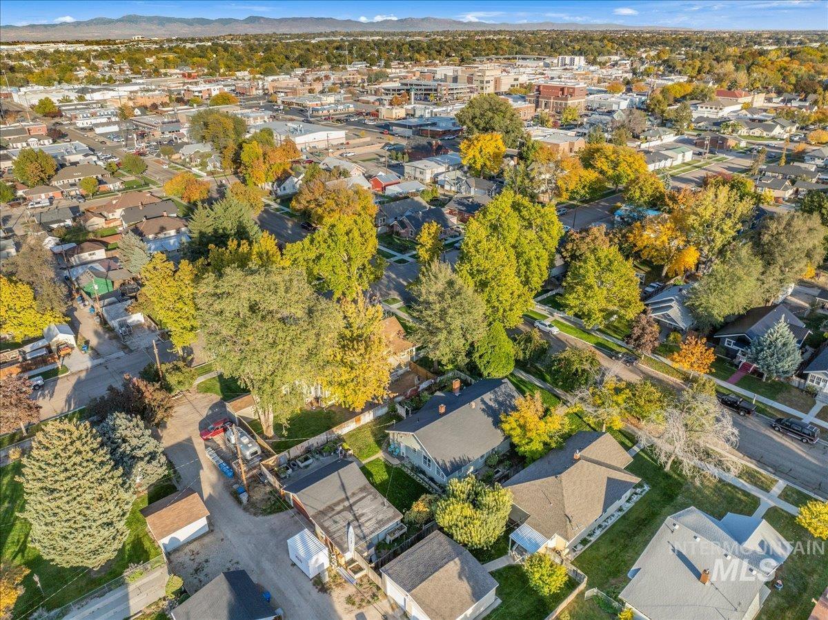 Aerial view of property and surrounding area with nearby suburban area and mountains