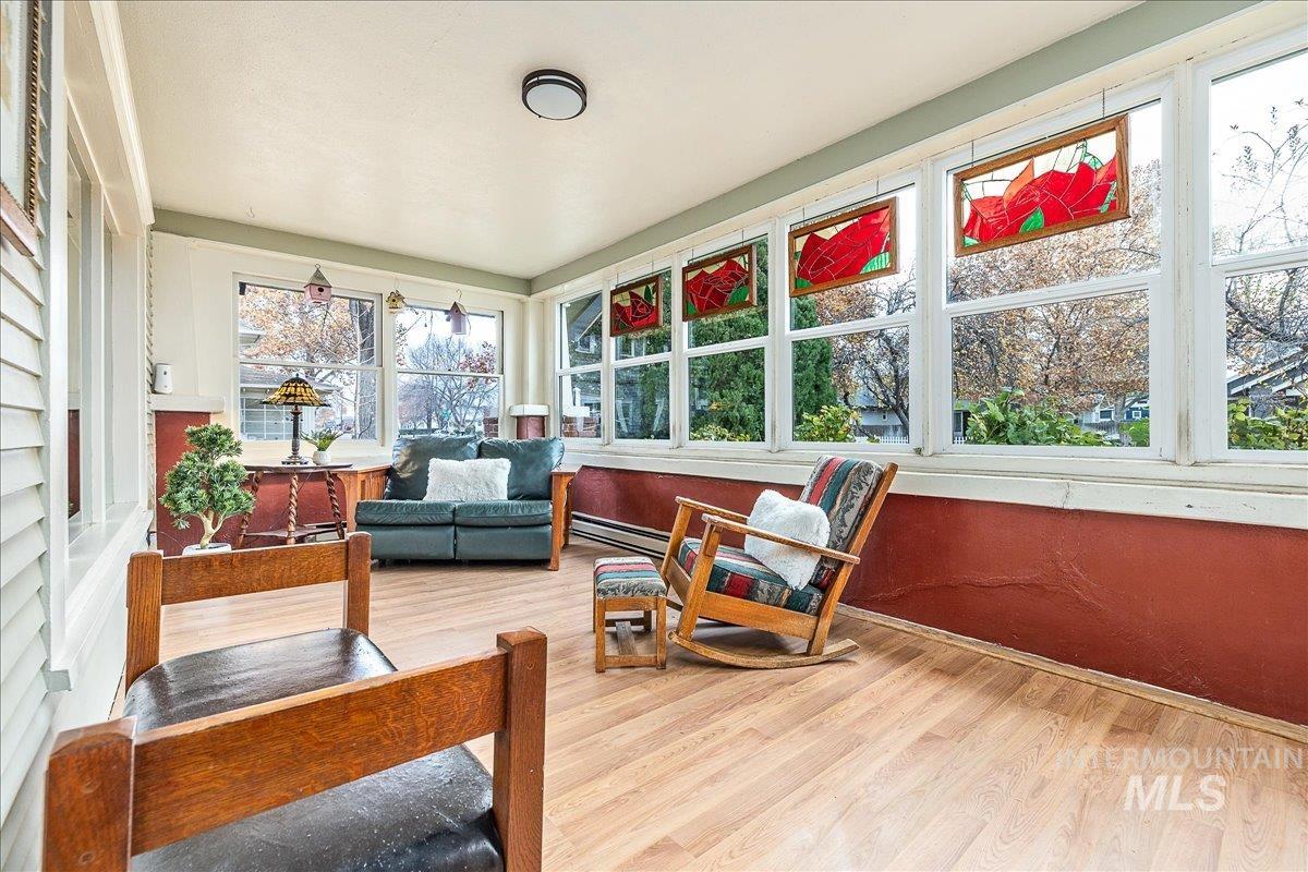 Sunroom / solarium featuring wood finished floors and baseboard heating