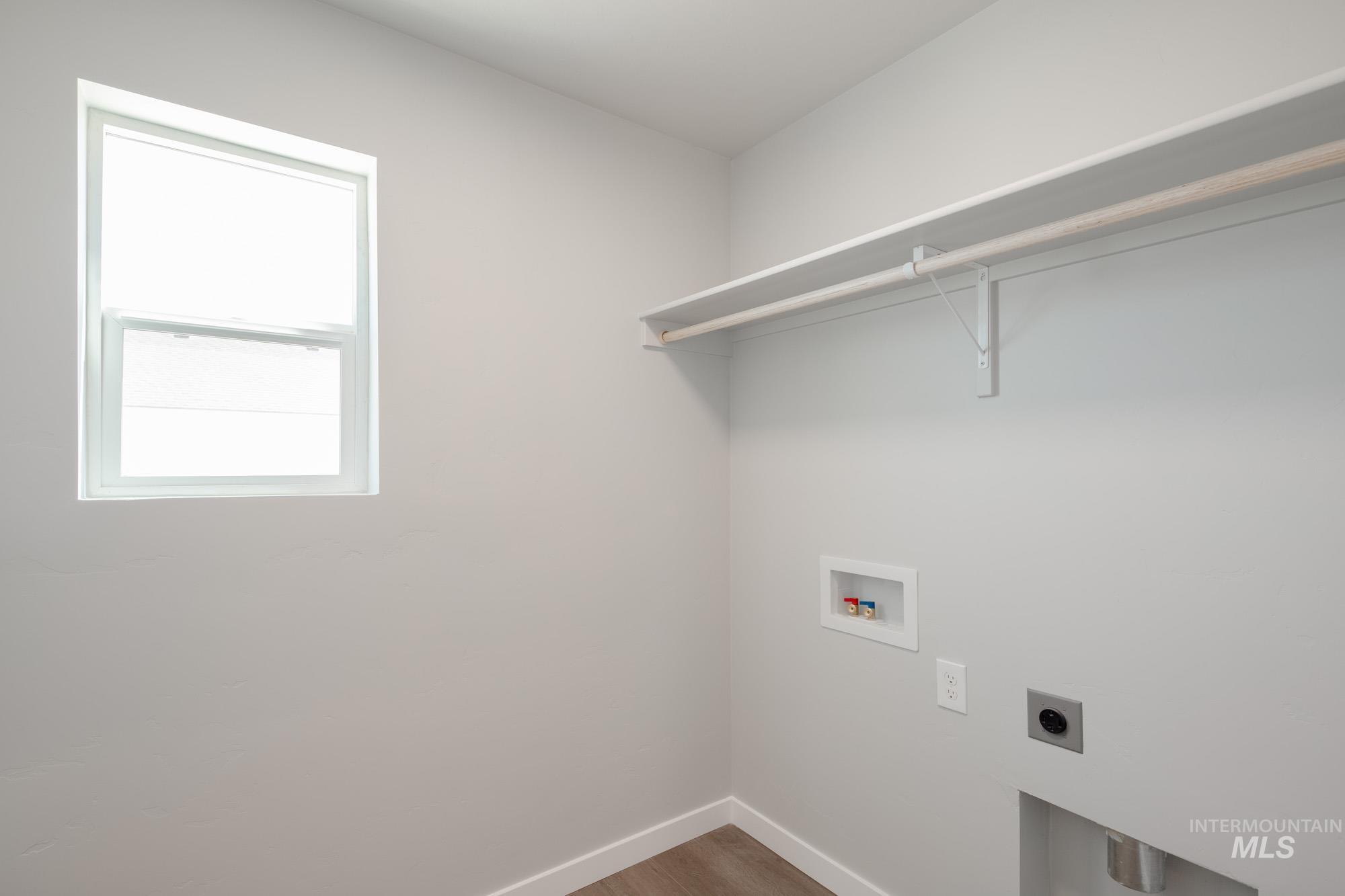 Laundry room featuring washer hookup, electric dryer hookup, and wood finished floors