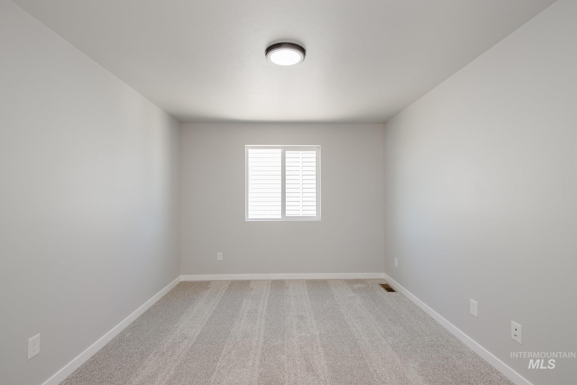 Spare room with light carpet and baseboards