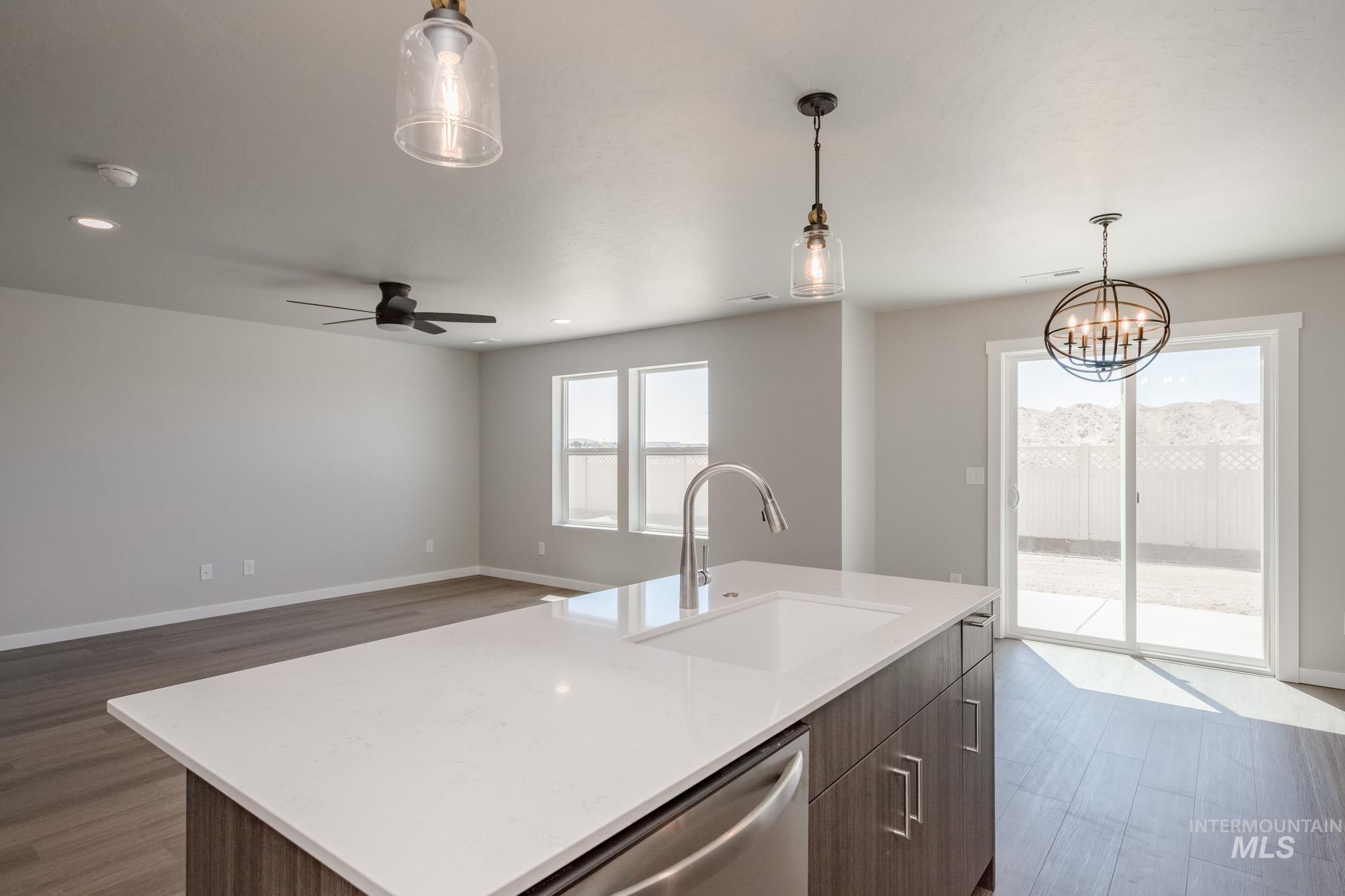 Kitchen featuring pendant lighting, dark wood-style flooring, an island with sink, healthy amount of natural light, and recessed lighting