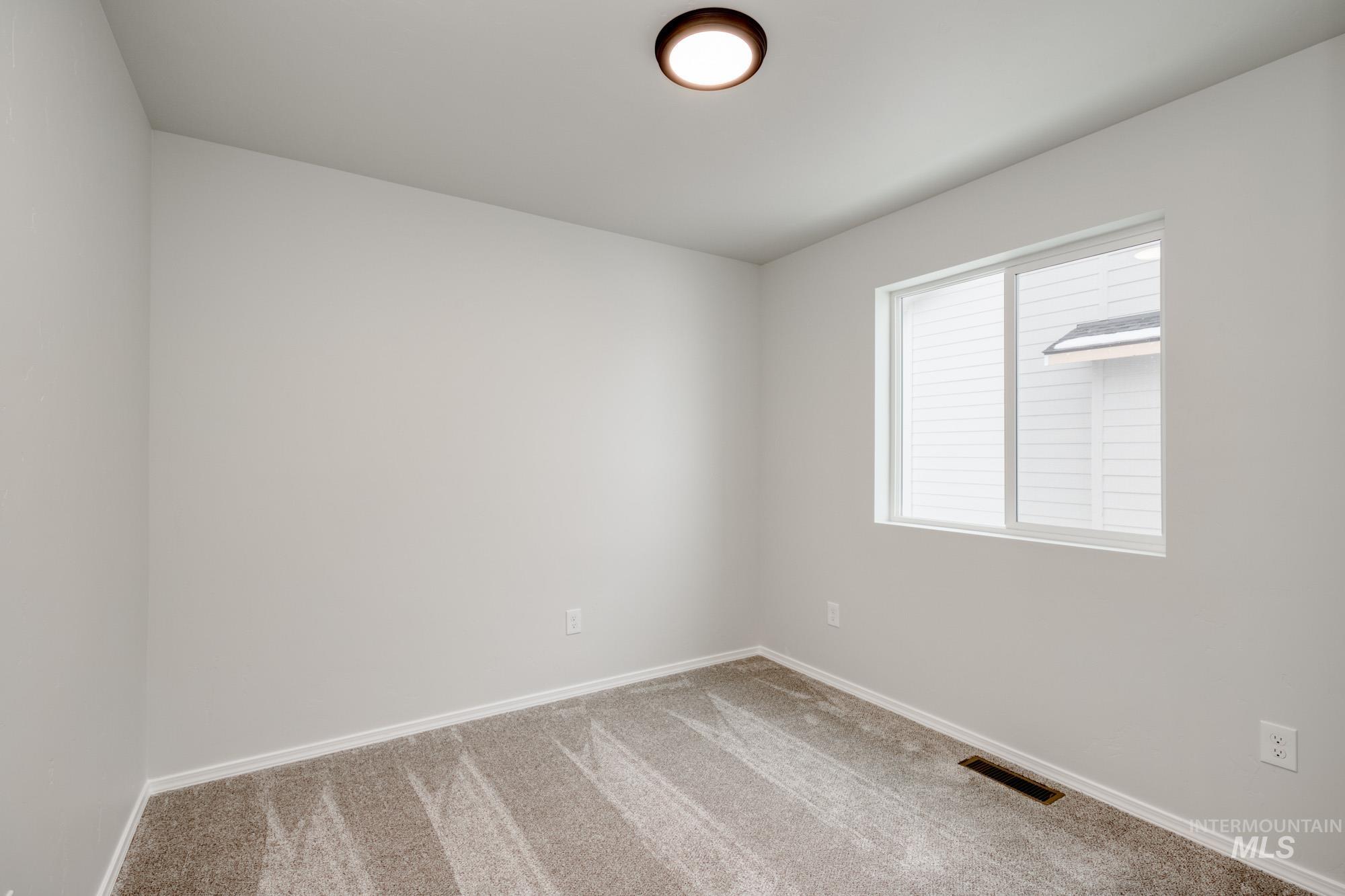 Carpeted empty room with baseboards