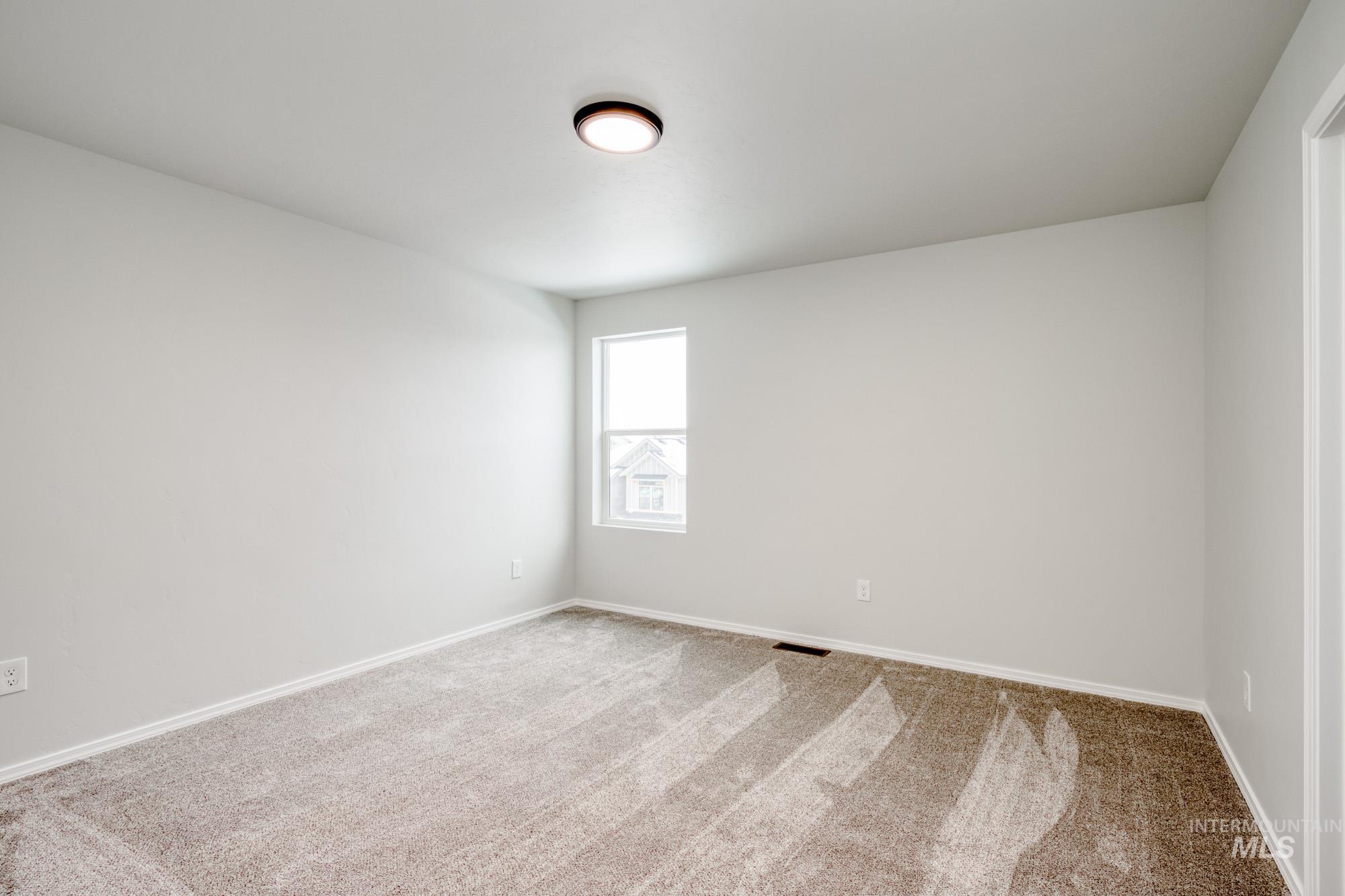 Carpeted empty room featuring baseboards
