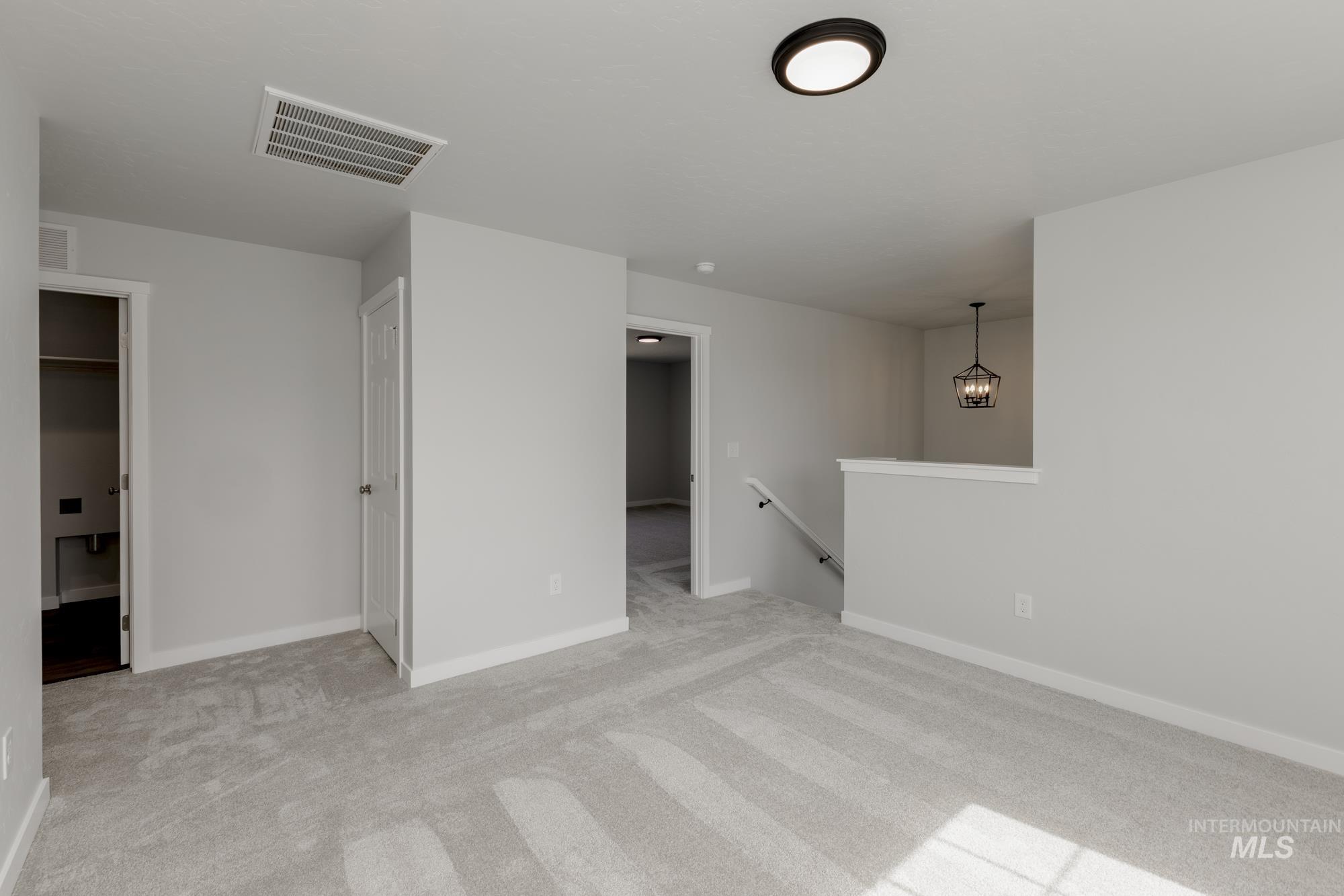 Spare room featuring light colored carpet and baseboards