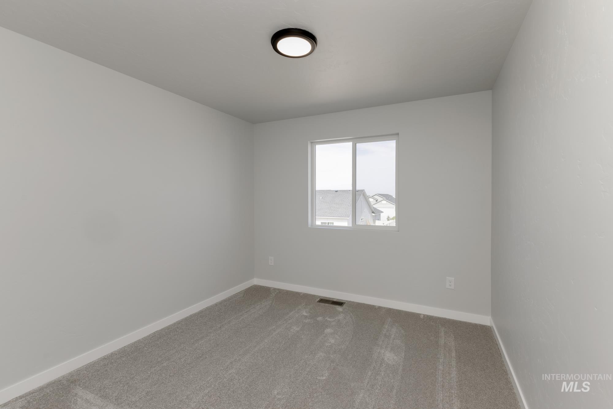 Empty room with carpet flooring and baseboards